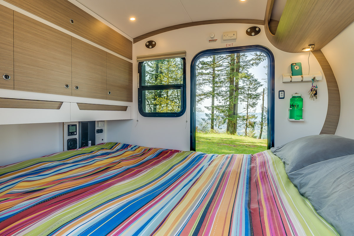 This RV rental offers a compact, cozy bedroom with overhead storage & a view of pine trees. Perfect for adventure!. Bean Trailer Bean Stock 2022