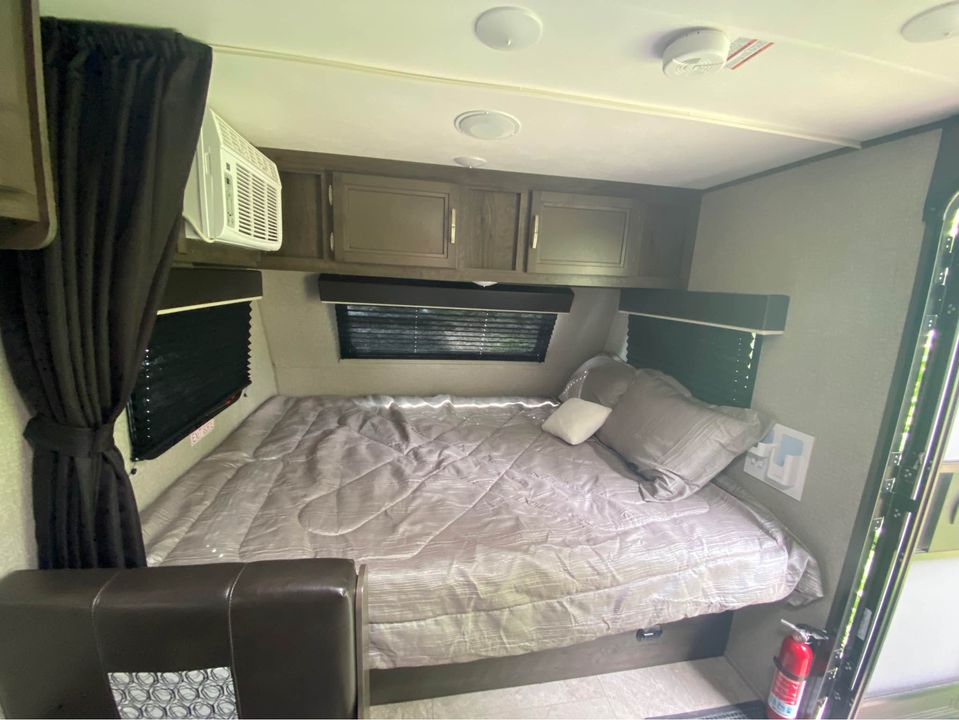 Experience comfortable travel with this **RV rental** bedroom interior, featuring a bed, AC, storage, & safety devices.. Jayco Jay Flight SLX Baja Edition 2020