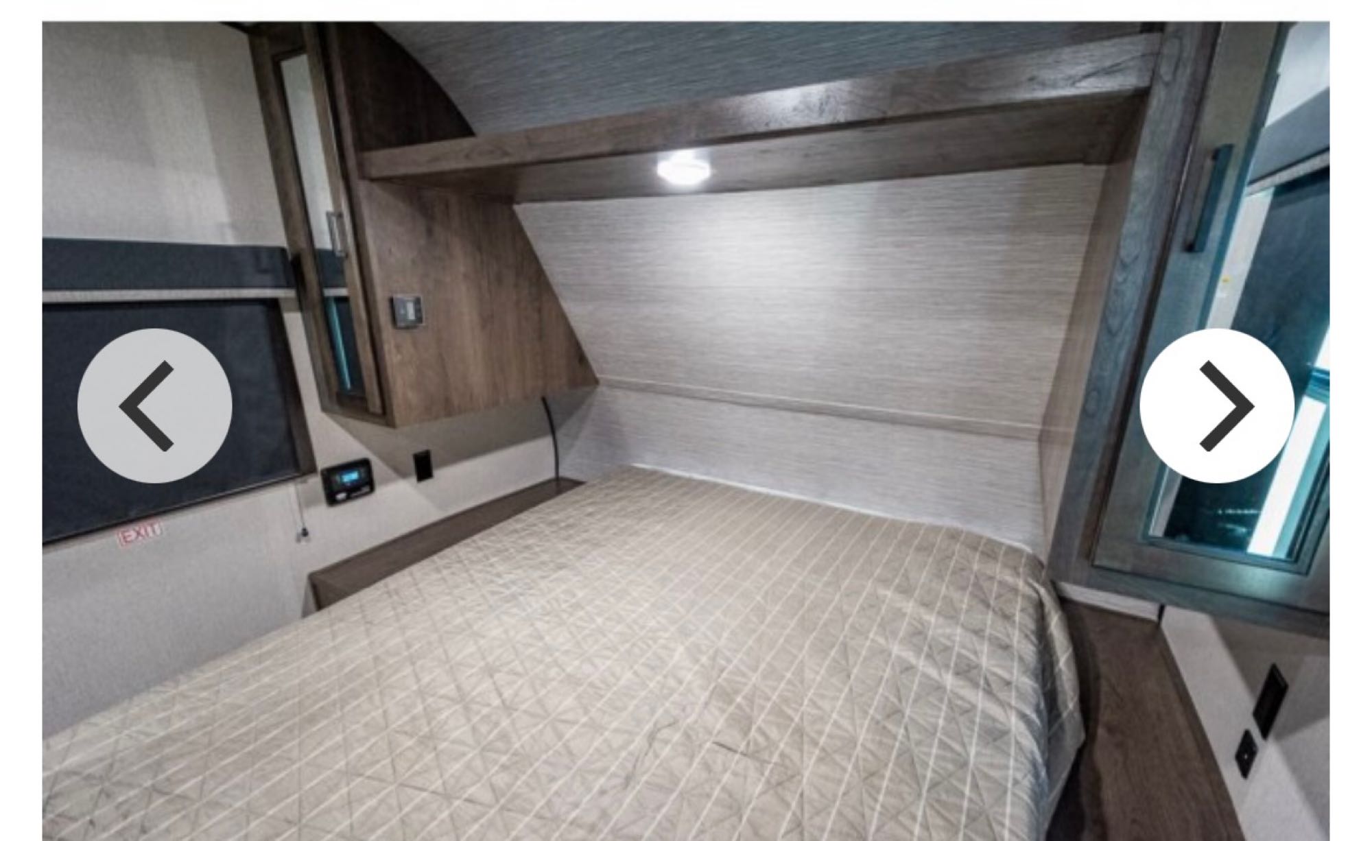 RV rental bedroom shows a light-colored, quilted bed with overhead cabinets and integrated lighting.. Other Other 2022