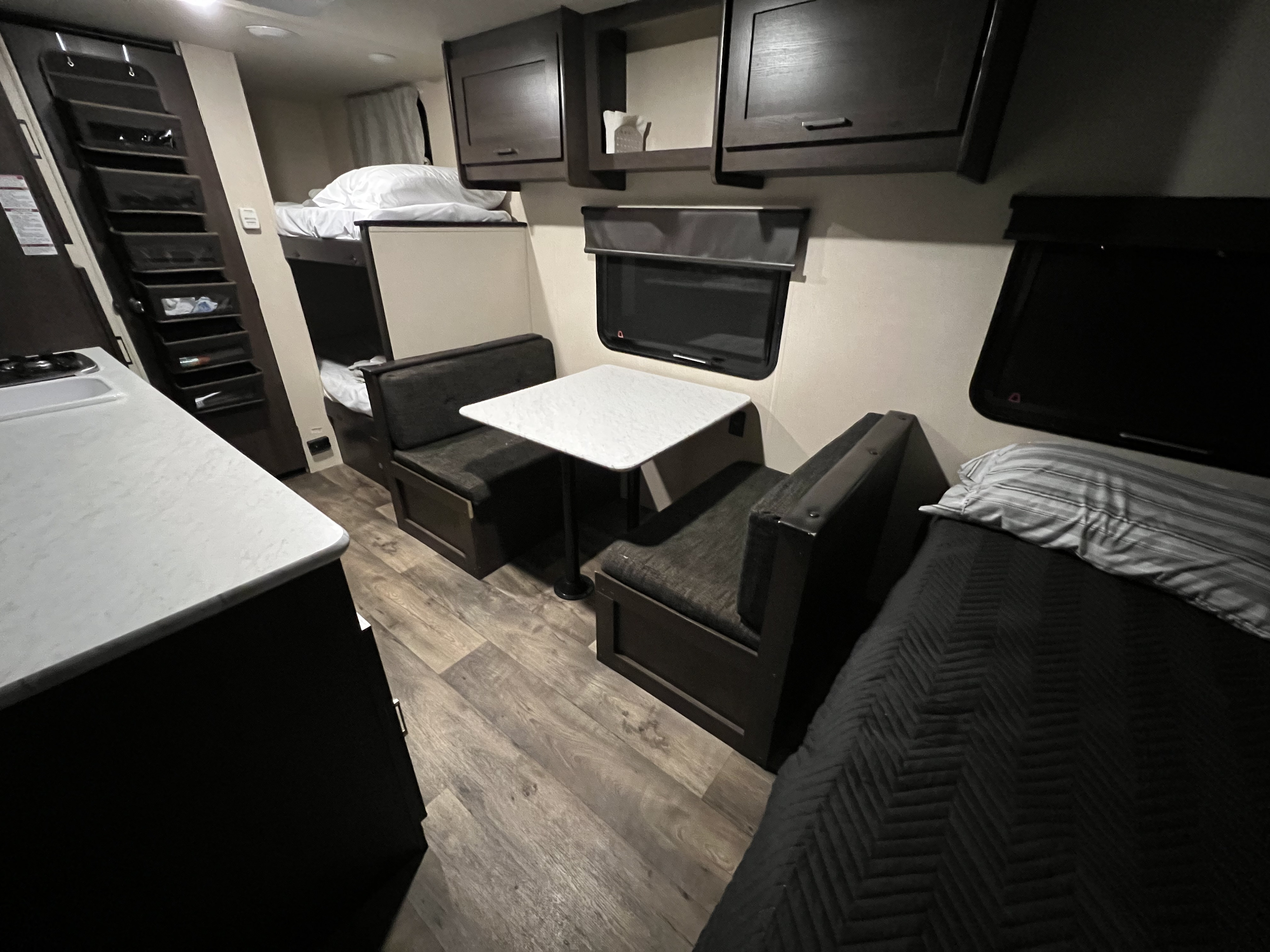 Cozy RV rental interior with dinette, bunk beds, and kitchen counter, perfect for comfortable travel and adventures.. Forest River Wildwood FSX 2018