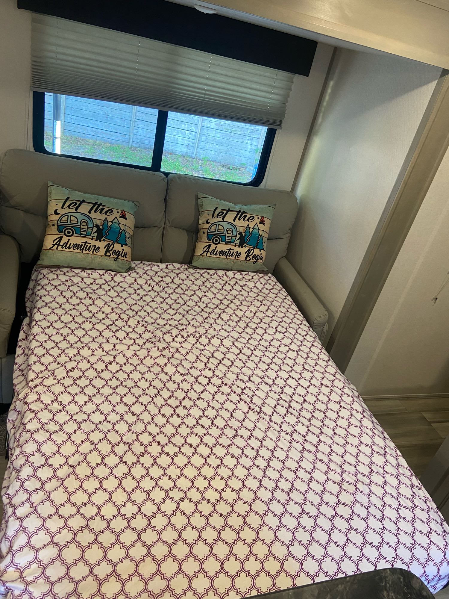 RV rental interior shows a sofa converted to a bed, with themed pillows and window blinds.. Other Tracer 2022