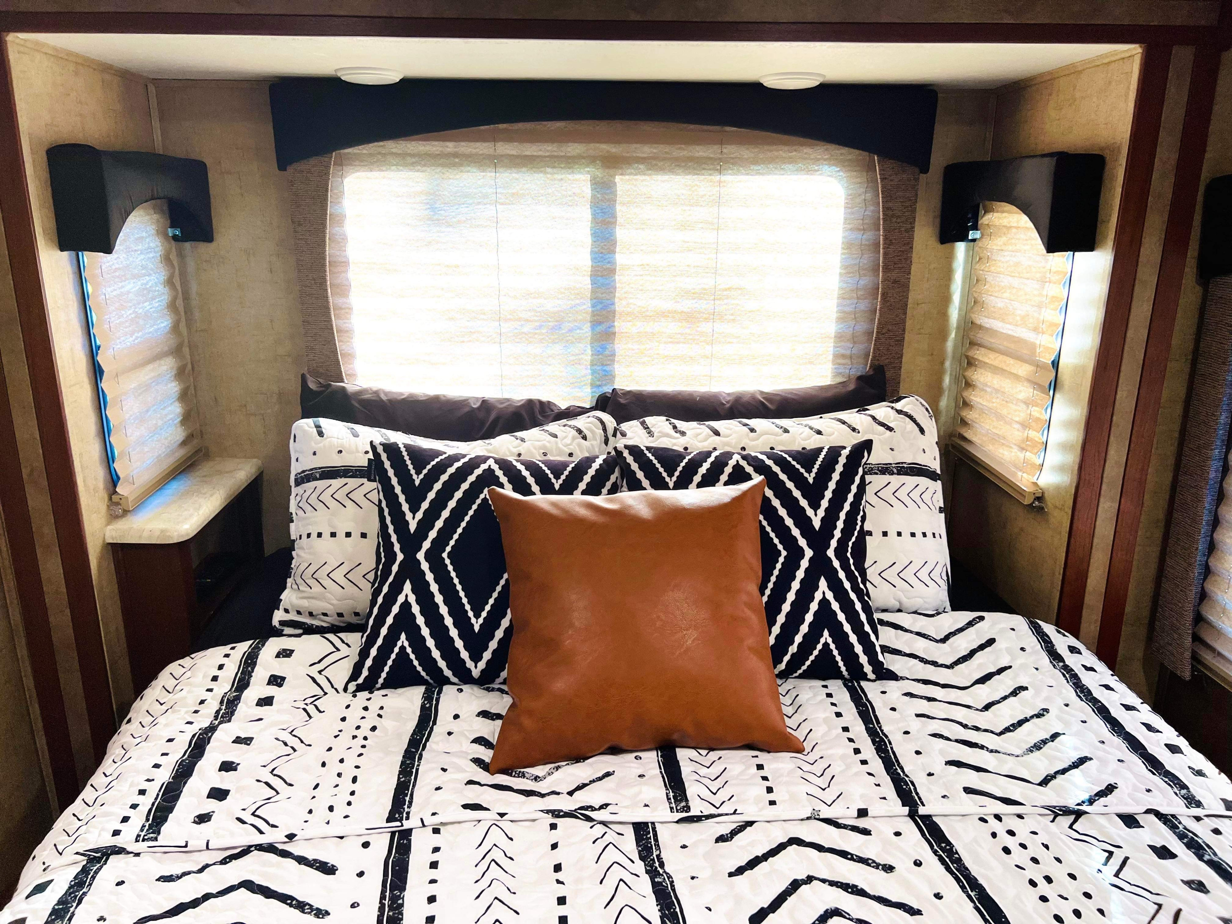 Cozy RV rental bedroom with a modern black & white patterned bed, accented by a warm brown pillow.. Forest River Other 2016