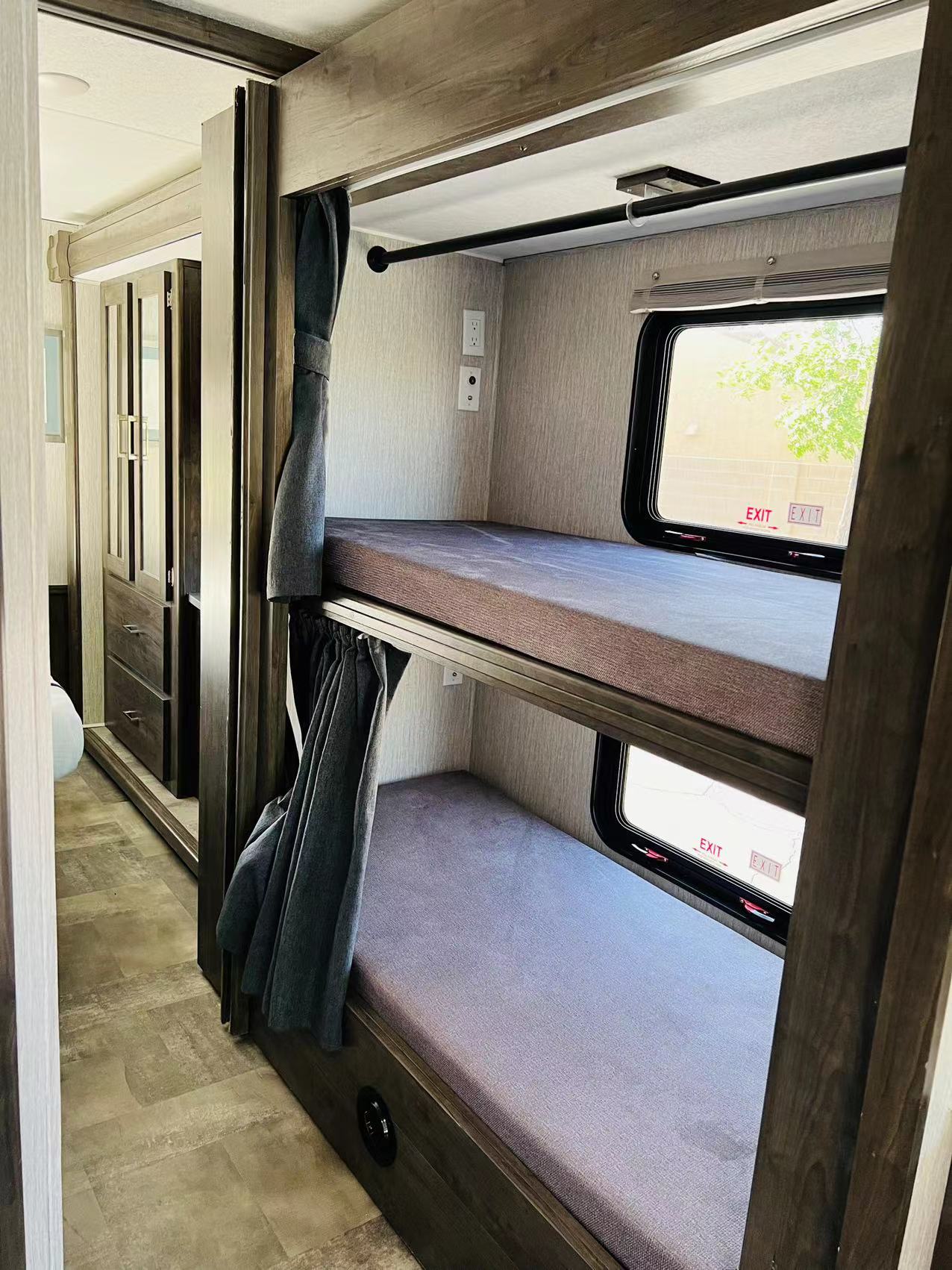Cozy bunk beds in an RV rental interior, featuring windows, outlets, and privacy curtains, perfect for family trips.. Forest River Coachmen Pursuit 2022