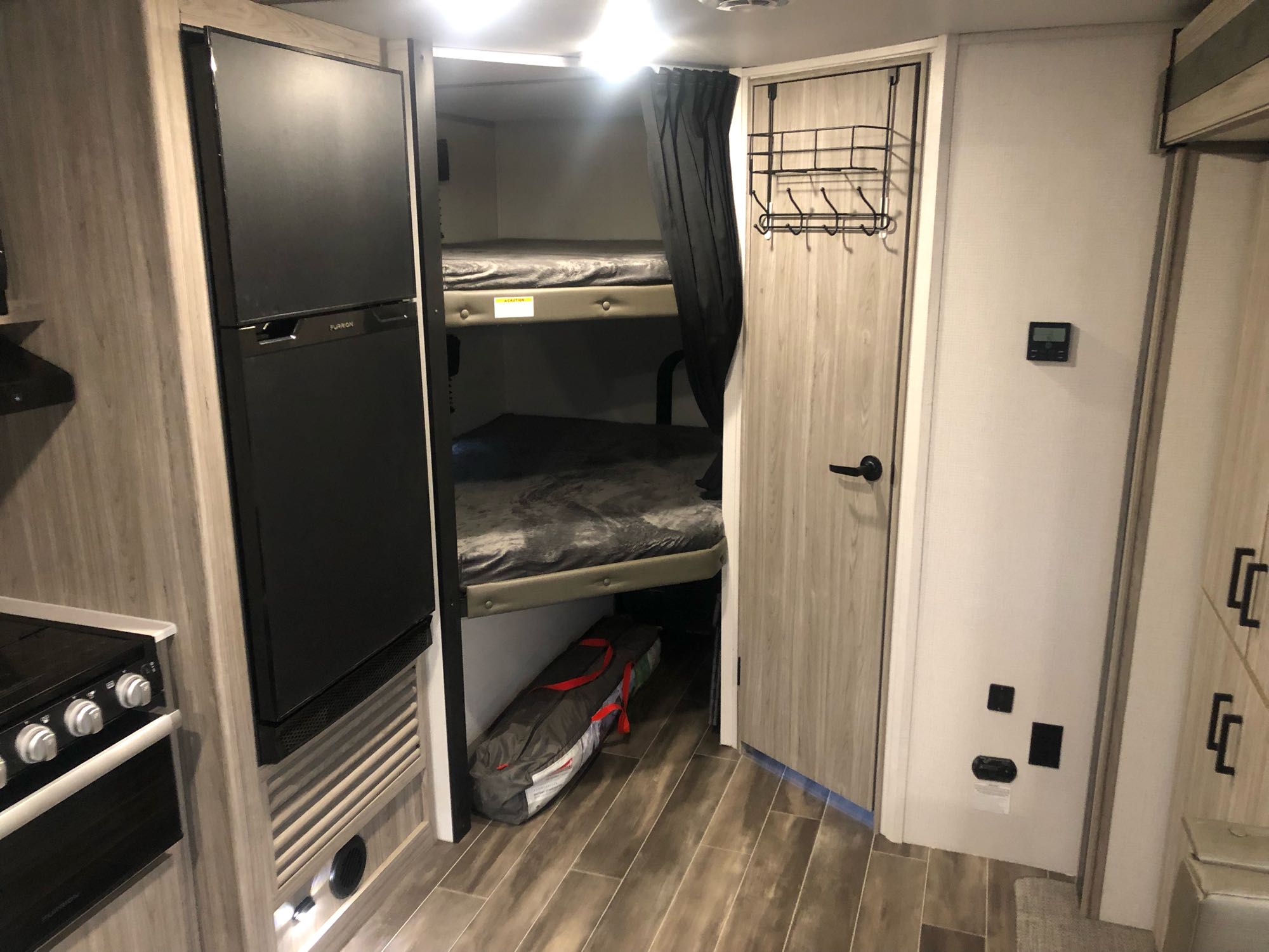 RV rental: Interior with bunk beds, privacy curtain, Furrion fridge, stove, & storage rack for easy living.. Other Passport 2022