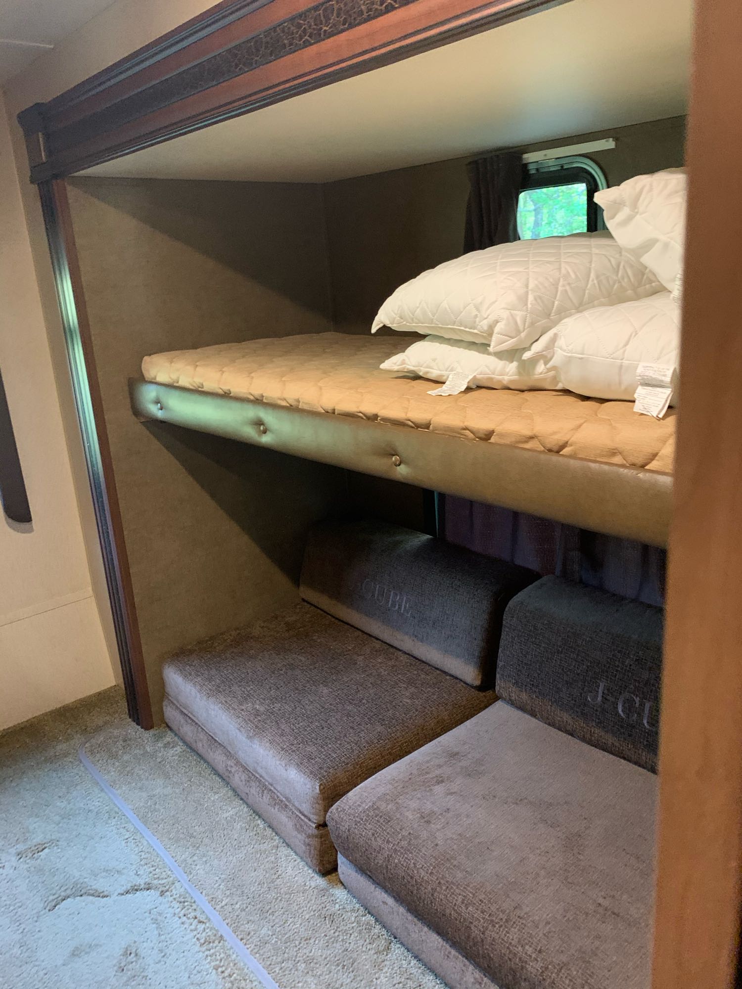 RV rental interior featuring a comfortable bunk bed setup with a window view, and convertible lower seating.. Jayco Jay Flight 2015