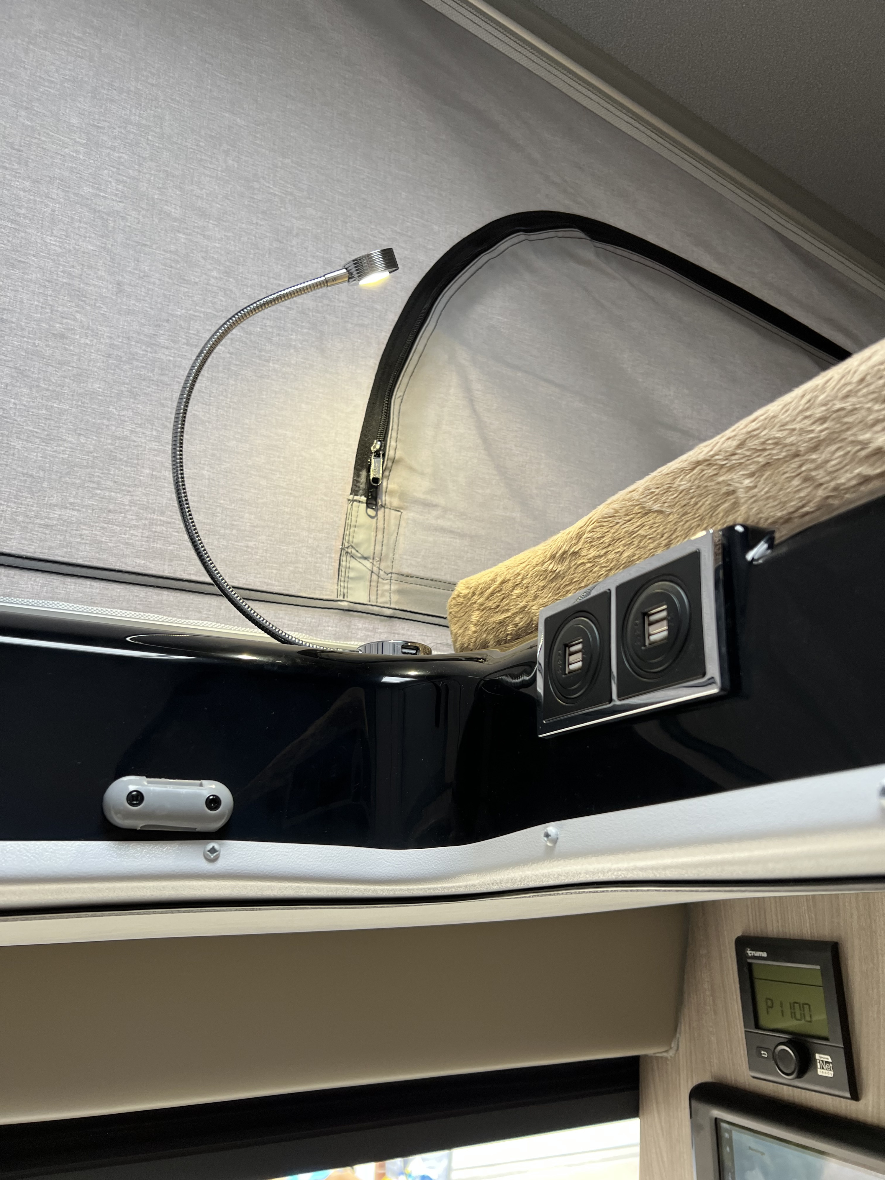 Cozy RV rental pop-top bed area with reading light, USB ports, and Truma control for comfort and convenience.. Thor Motor Coach Sequence 2022