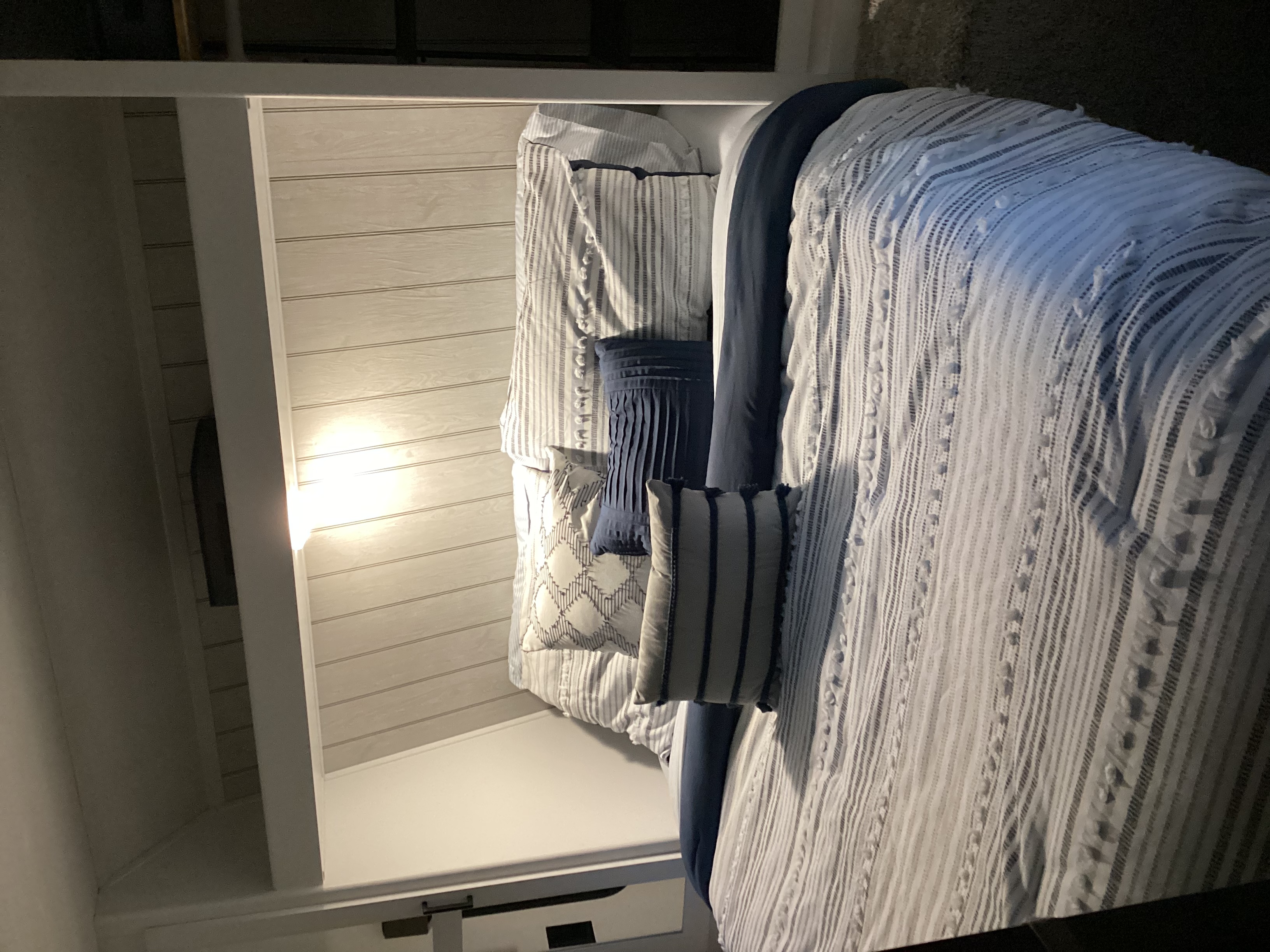 Comfortable RV rental bunk bed features stylish striped and textured blue & white bedding.. Keystone Hideout 262BH 2022