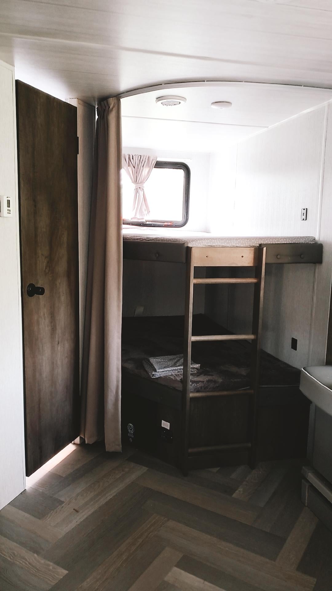 RV rental interior: two modern bunk beds with a ladder, herringbone wood floor, and a window for natural light.. Forest River Other 2022