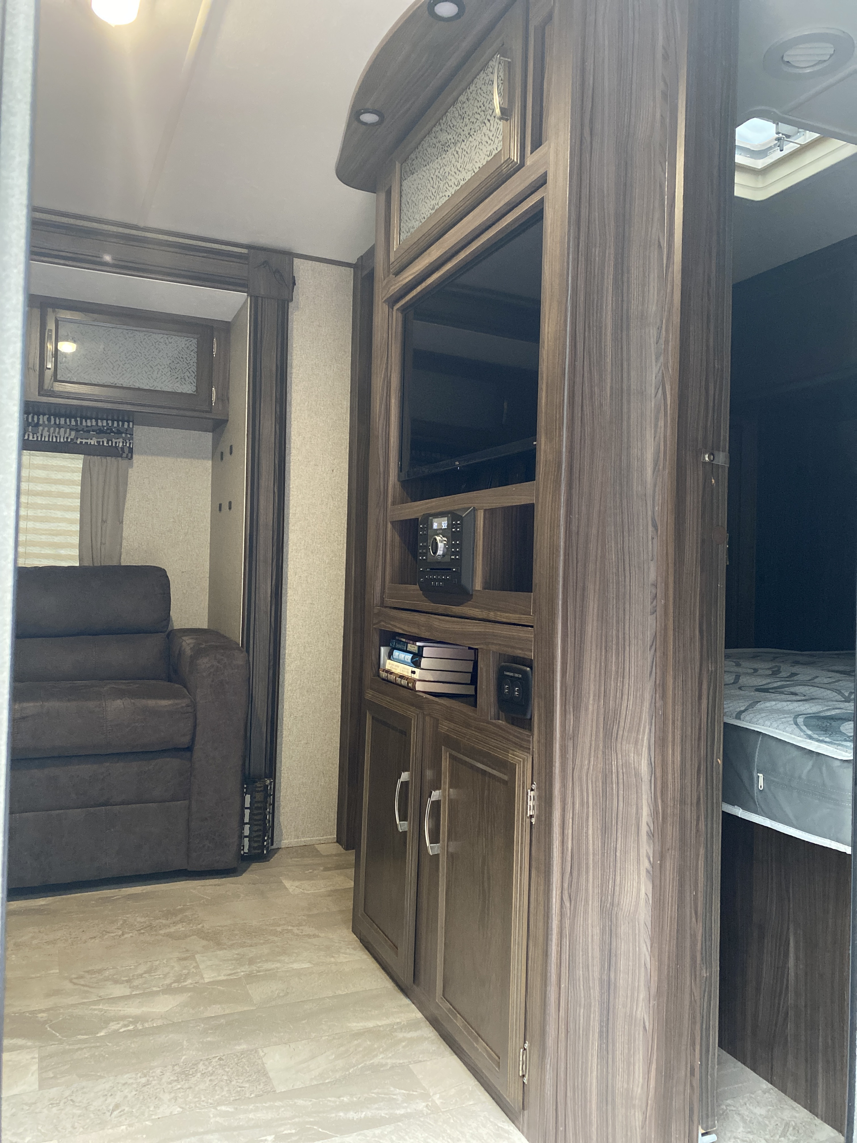 RV rental interior: Modern living area with a plush sofa, entertainment center, and a glimpse of the bedroom.. Coachmen Other 2019