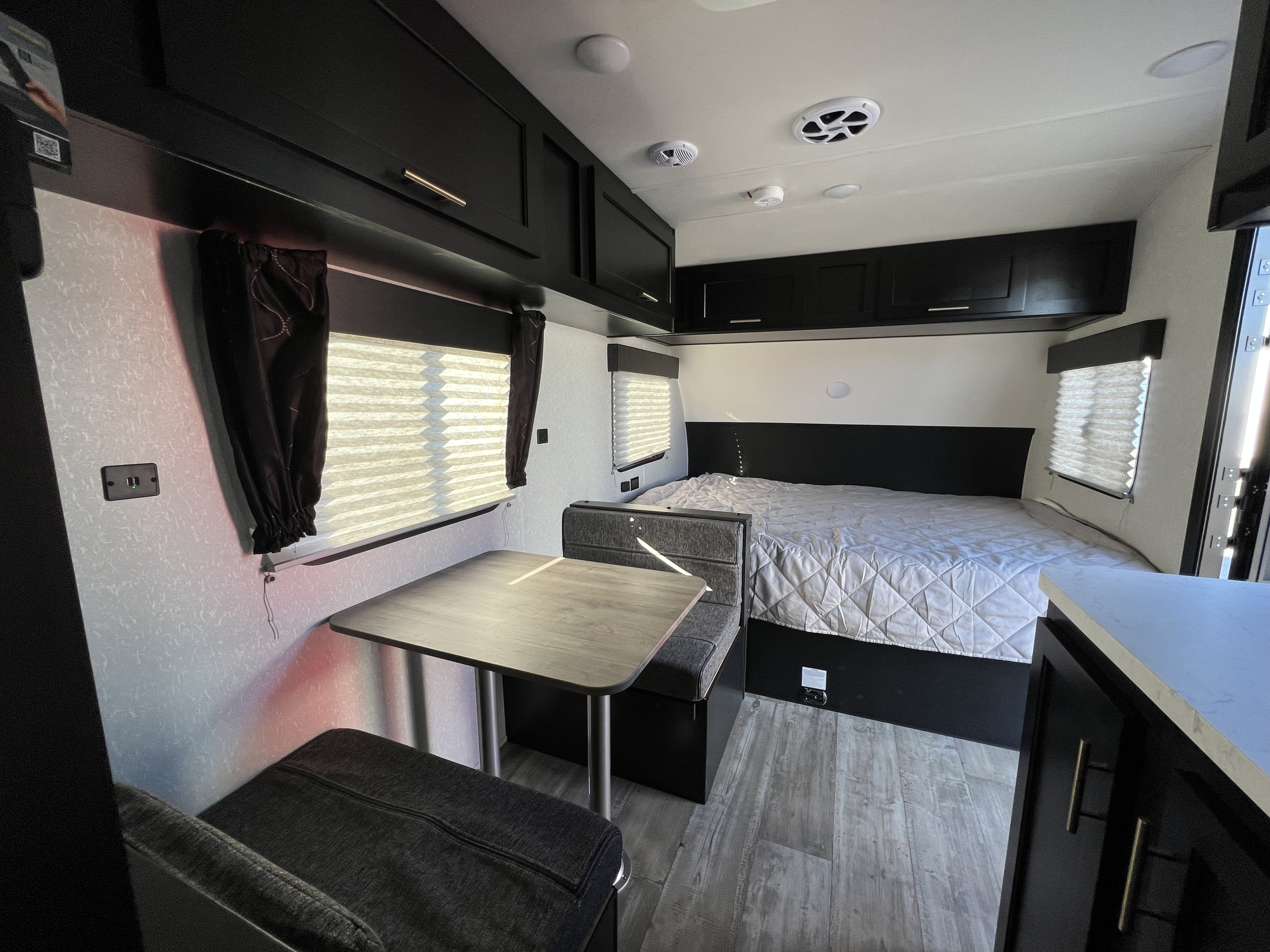 Clean, modern RV rental interior featuring a cozy bed, dinette, and ample storage cabinets.. Forest River Cherokee Wolf Pup 2022