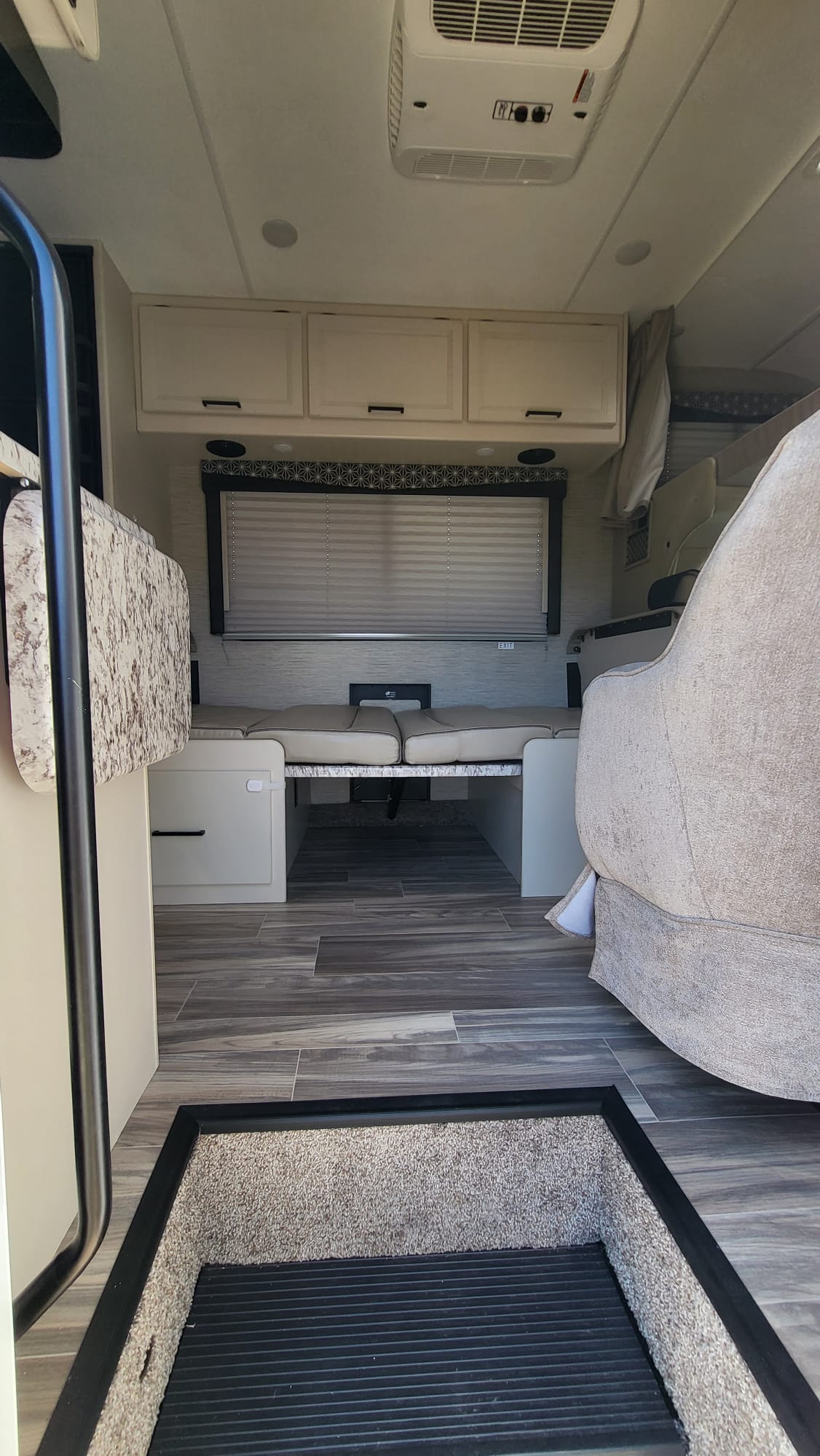 From the entrance, an RV rental interior with a cozy dinette that converts to a bed, overhead storage, and AC.. Ford Freedom Elite 2022
