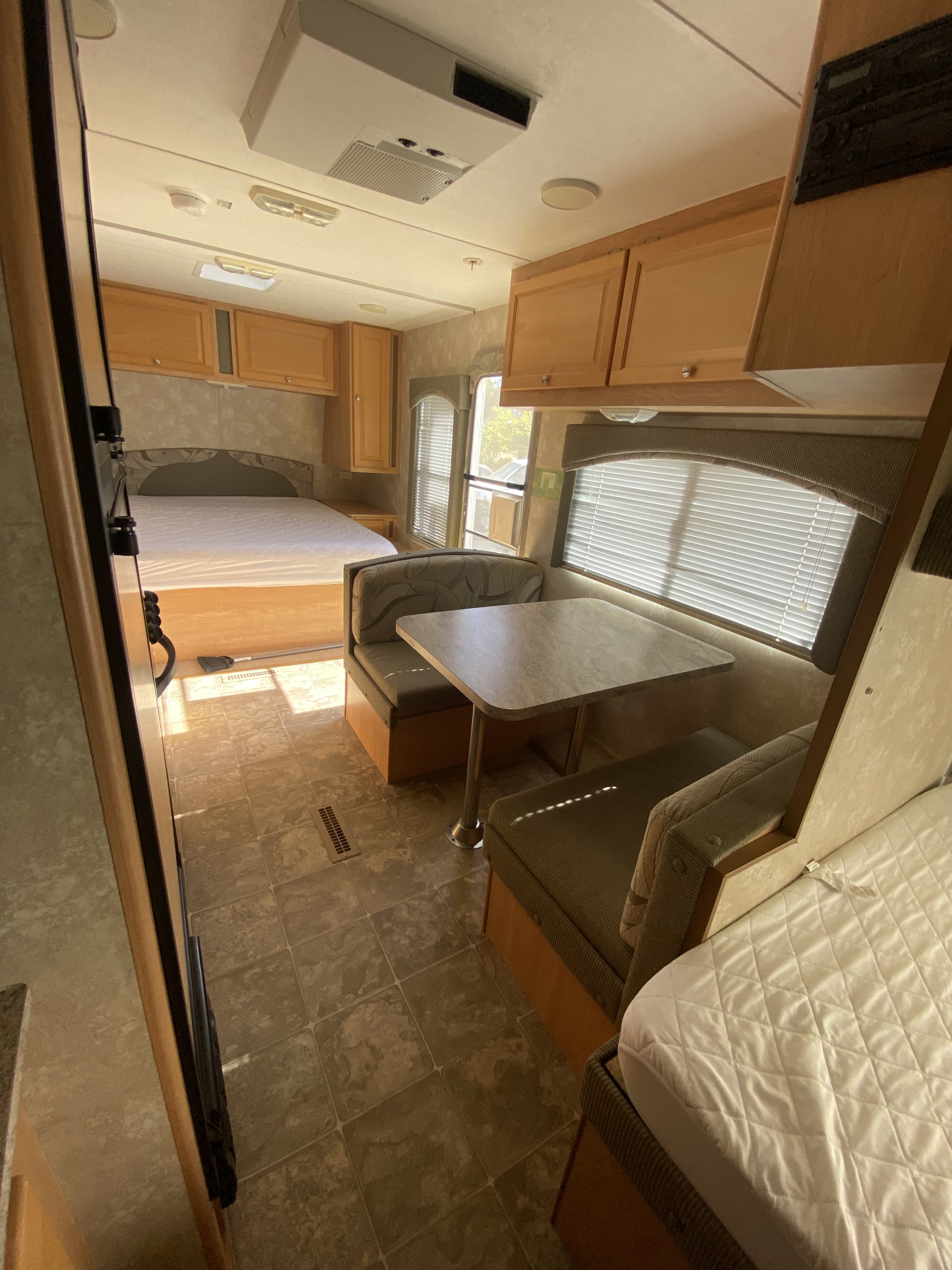 RV rental interior: main bed, dinette with table & bench seats, overhead cabinets. A comfortable RV.. Thor Summit 2008