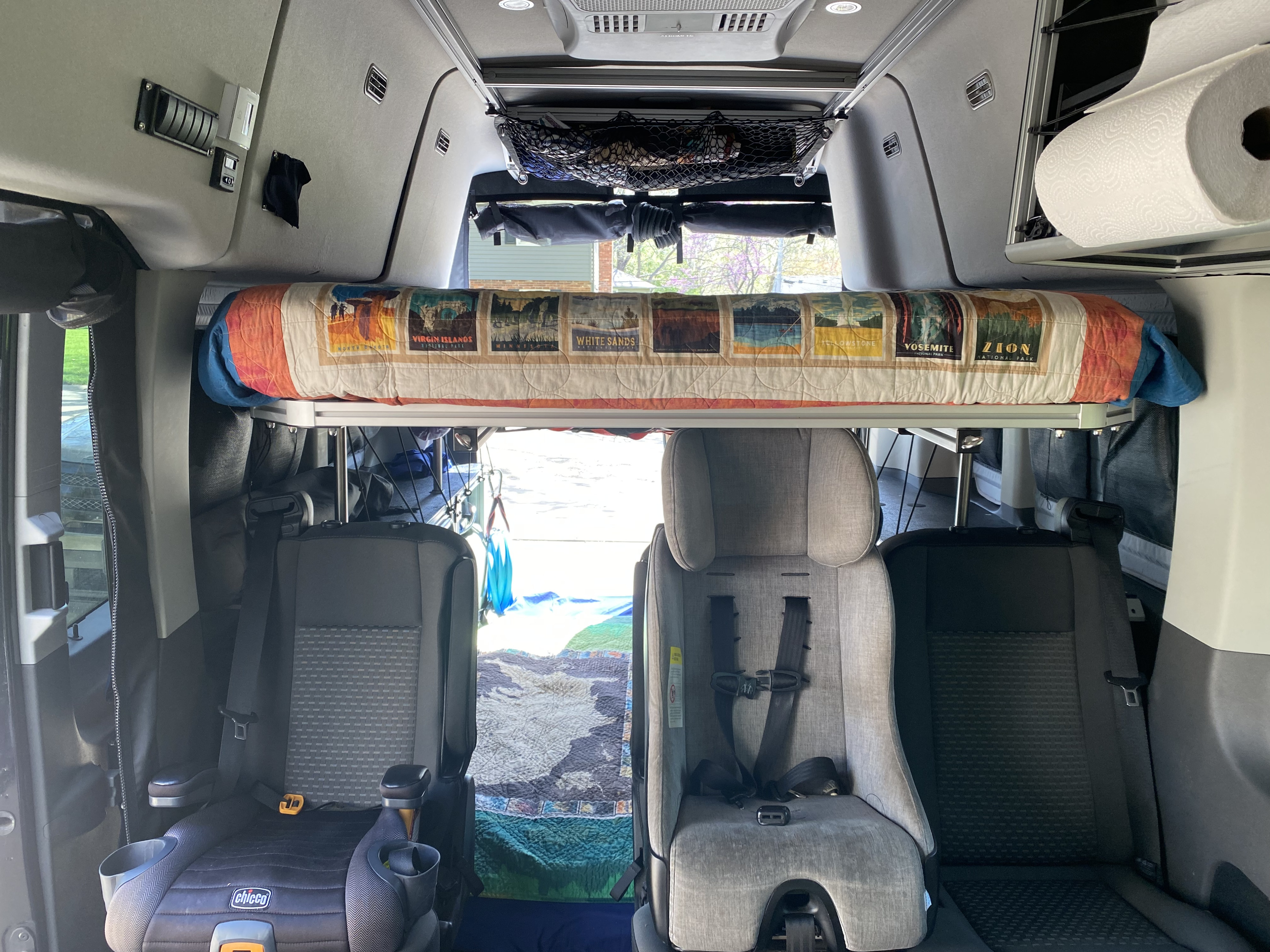 RV rental interior with a cozy bunk bed featuring National Park designs and two child car seats.. vandoit LIV 2020