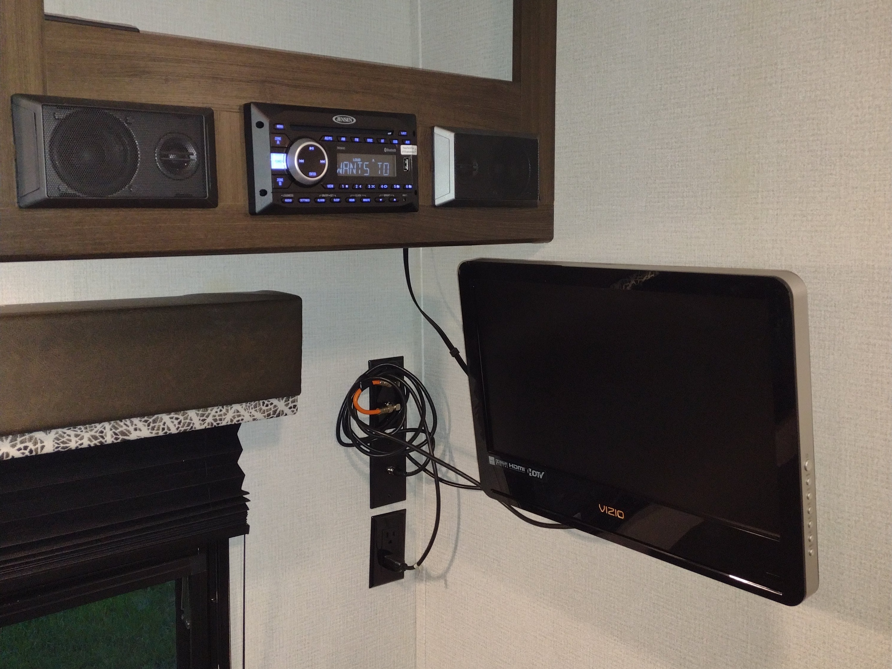 An RV rental features a Jensen stereo with speakers and a wall-mounted Vizio TV, providing entertainment for your trip.. Keystone Springdale 2020