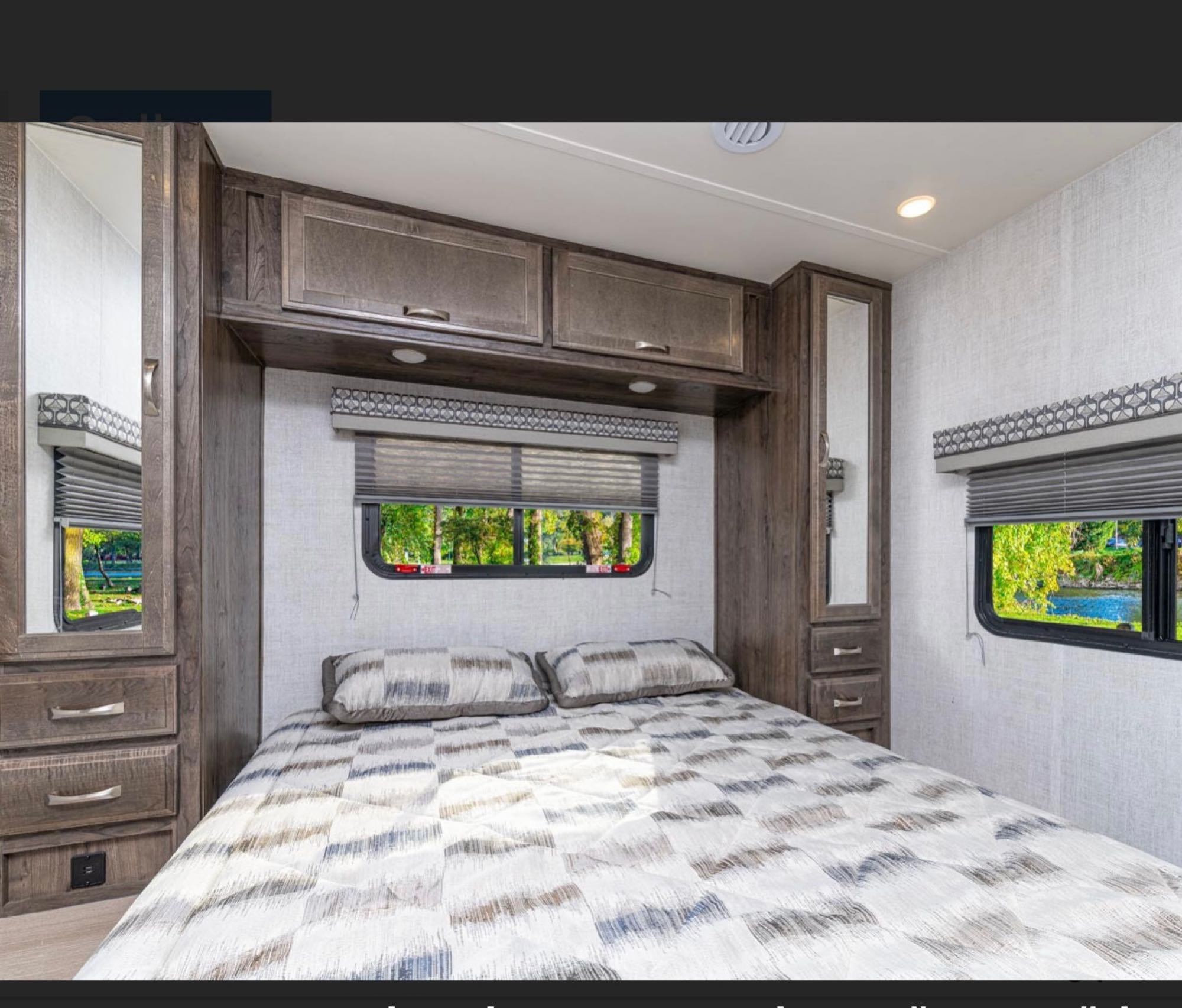 Comfortable RV rental bedroom: cozy bed, wood cabinets, mirrored wardrobes, and windows revealing nature.. Gulf Stream Conquest 2021