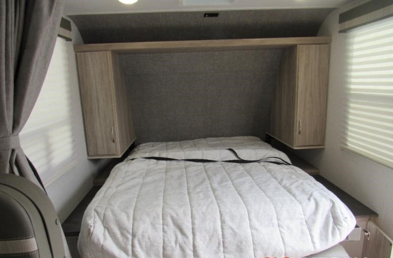 RV rental bedroom: Features a comfortable bed, overhead storage cabinets, window blinds, and privacy curtain.. Minnie Micro Minnie 2022