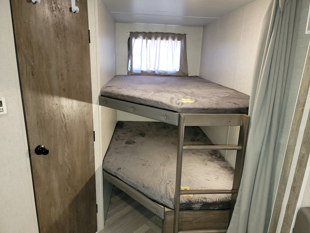 RV rental interior: two cozy bunk beds with gray mattresses, ready for adventure and family trips.. Forest River Salem 2021