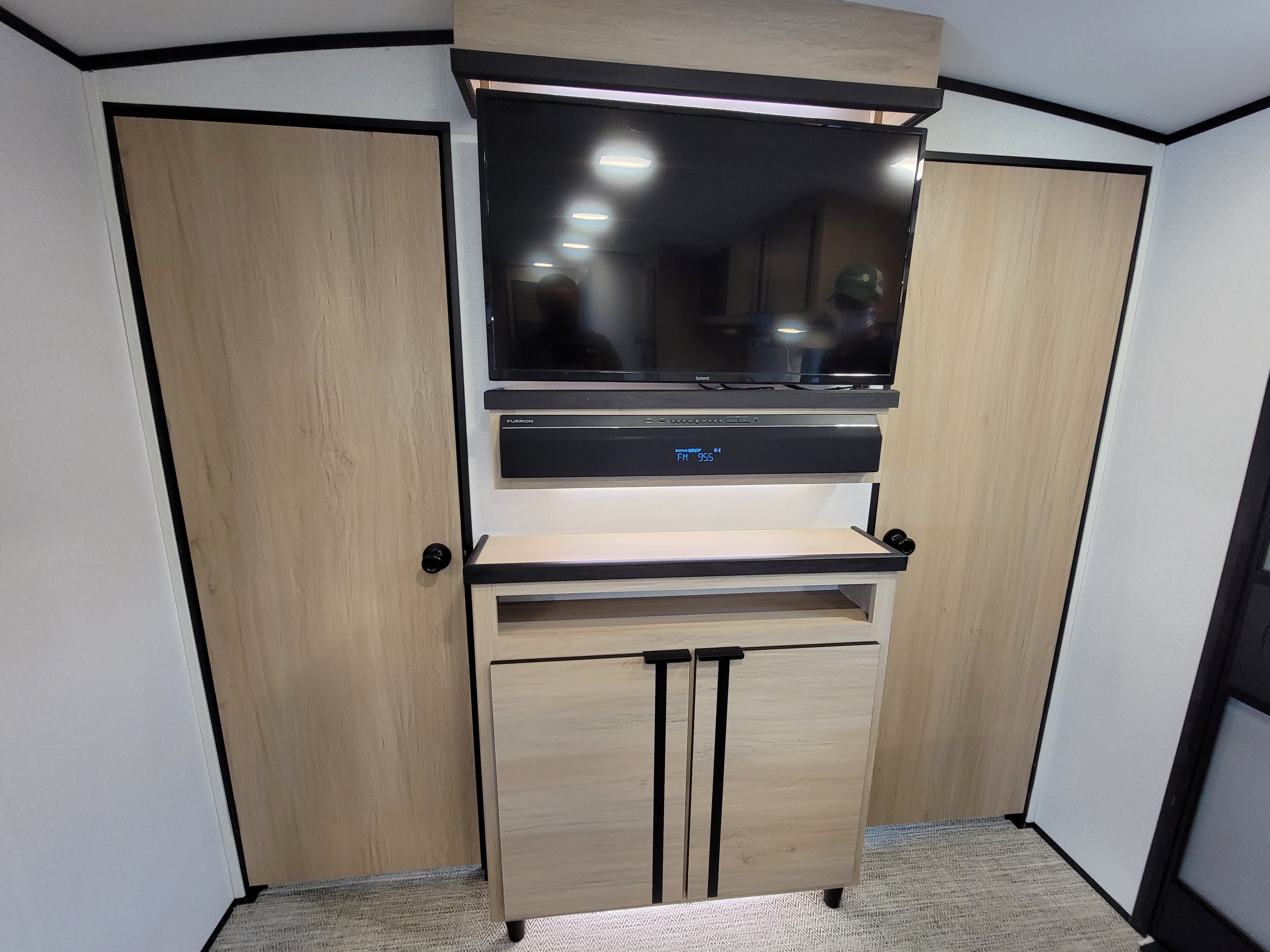 Spacious RV rental living space featuring a sleek entertainment console, TV, soundbar, and built-in closets.. Cruiser Rv Corp Radiance 30ds 2021