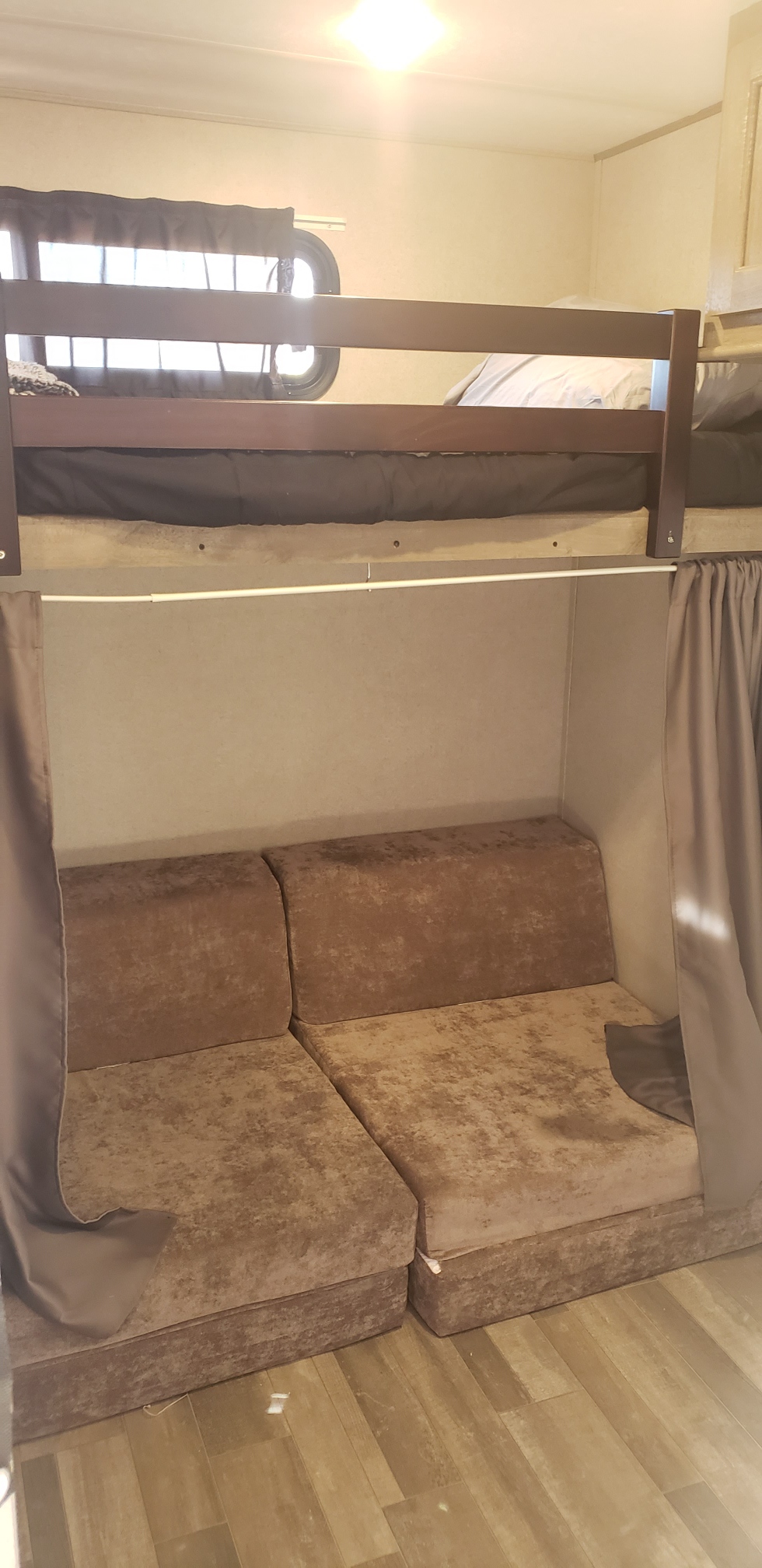 RV rental with clever bunk beds: lower bunk converts to a comfortable sofa, complemented by privacy curtains and a window.. Forest River Vibe 2021