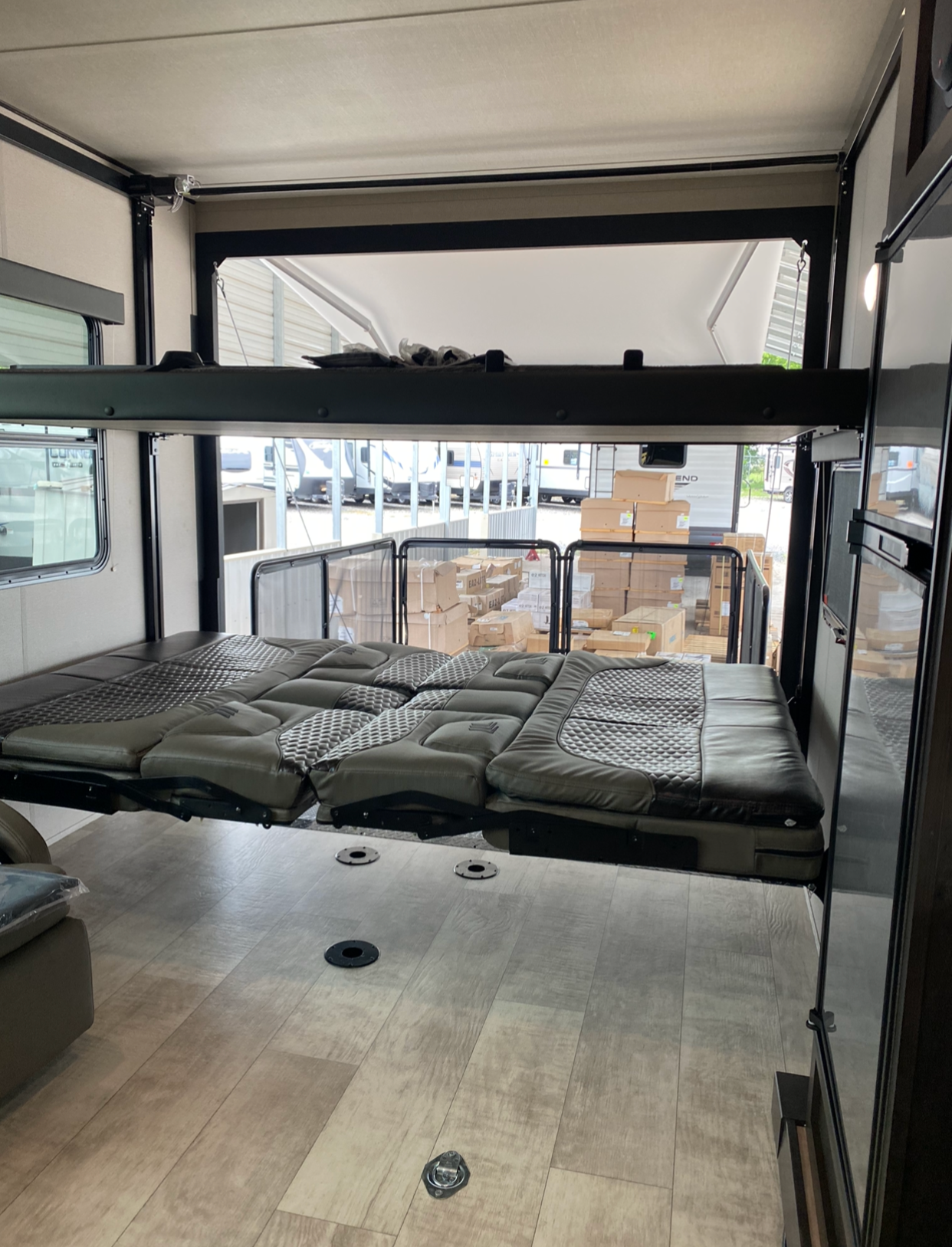 RV rental interior: A versatile space featuring a lowered, convertible bunk bed/sofa system and a spacious garage area.. Grand Design Momentum 2021