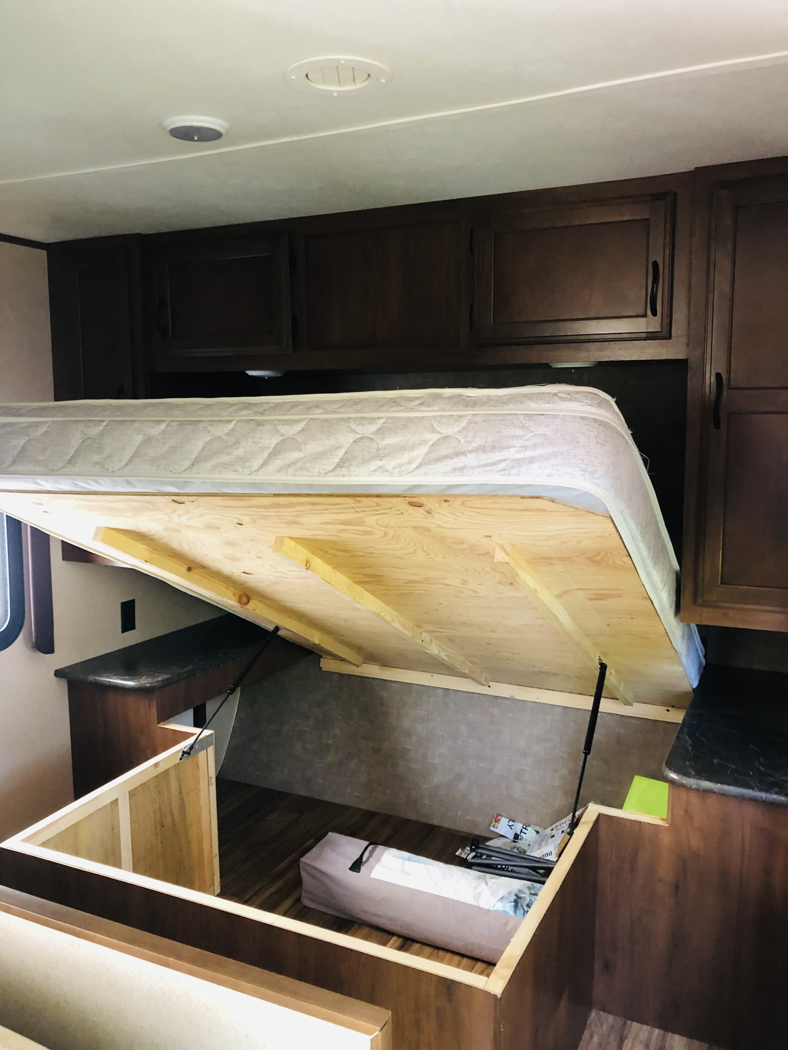 RV rental bedroom features a lift-up bed revealing under-mattress storage, plus convenient overhead cabinets.. Jayco Jay Flight 2016