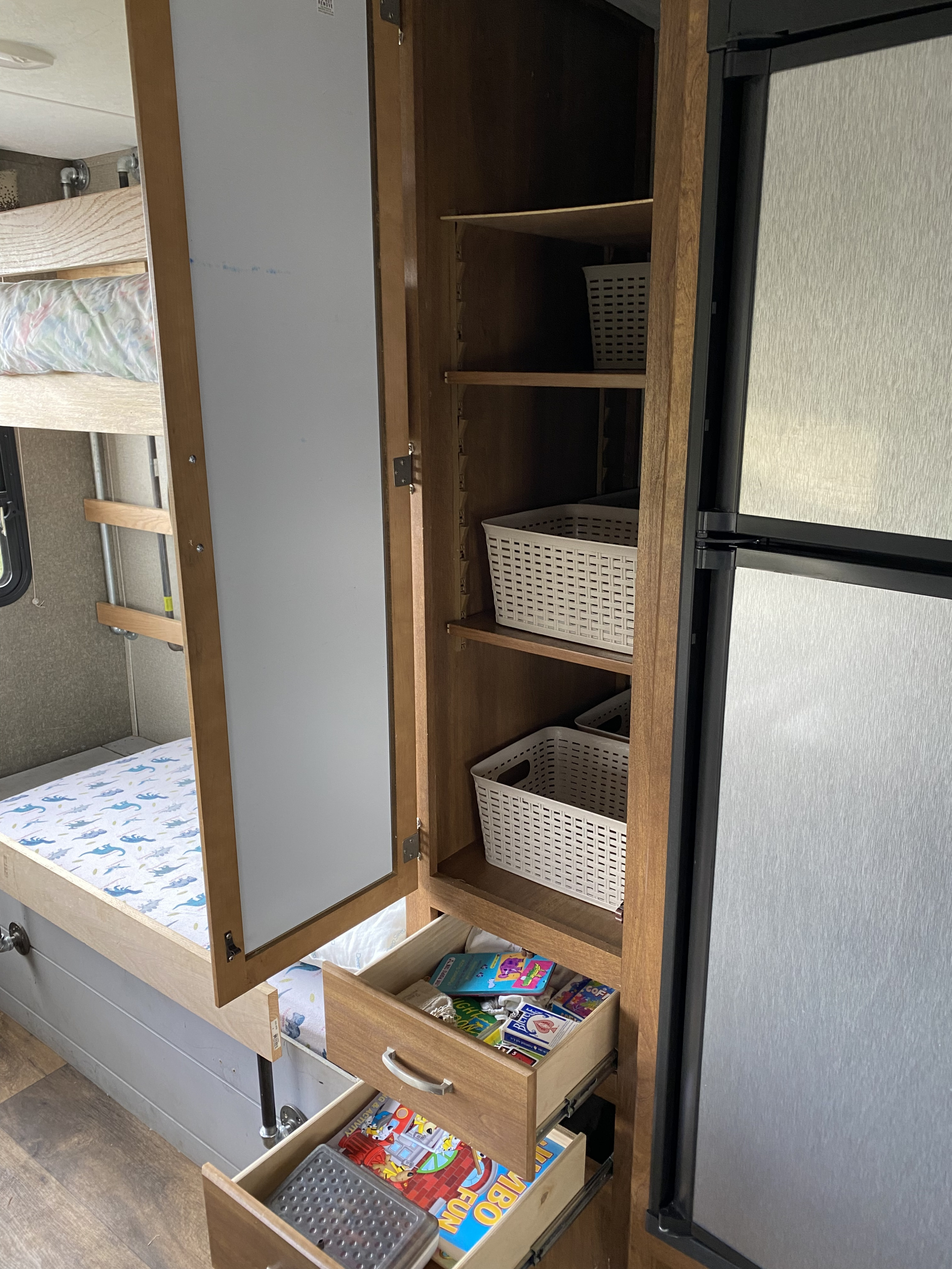 RV rental: interior with cozy bunk beds, a cabinet featuring organized baskets, and open drawers filled with activities.. Keystone RV Springdale 2017
