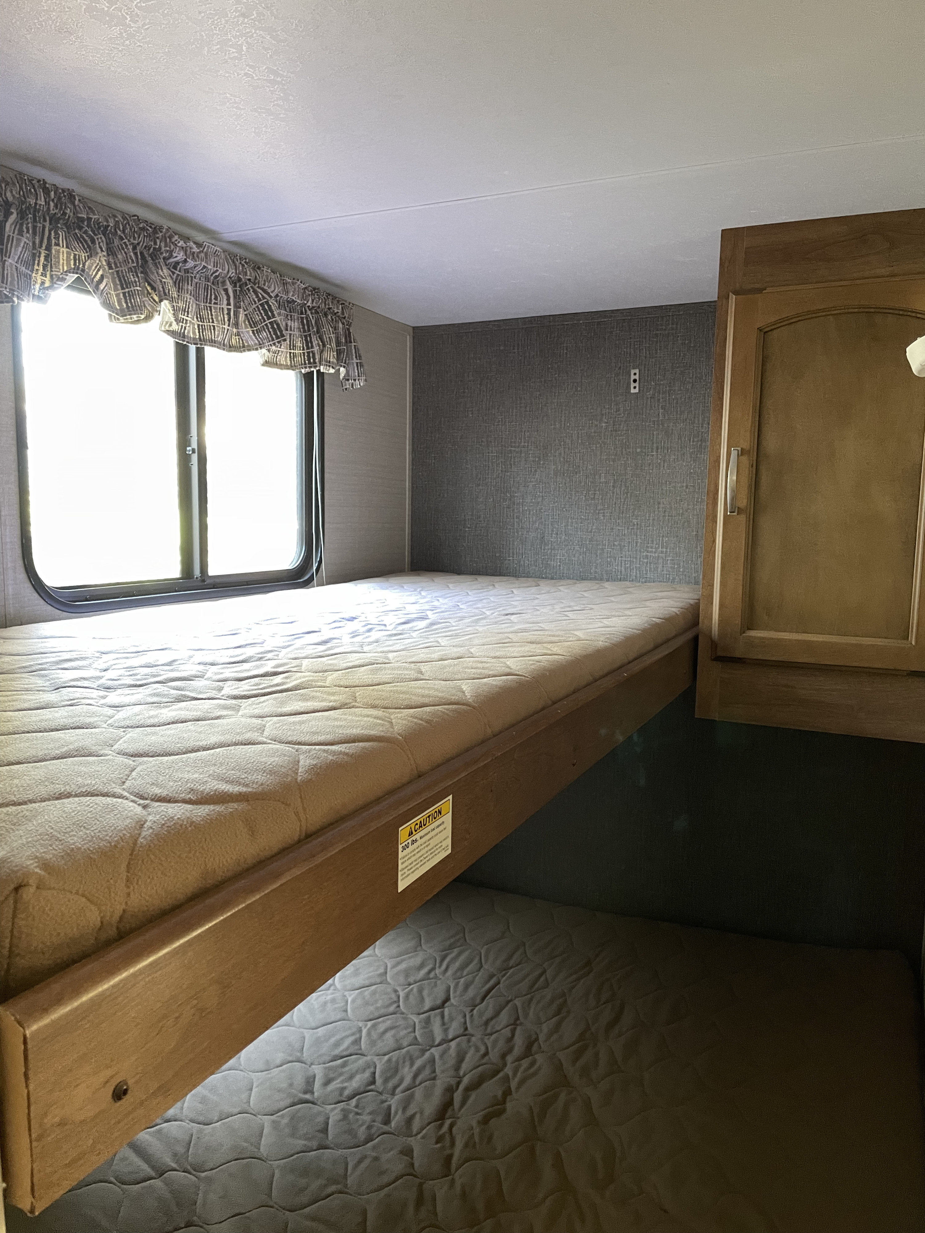 Cozy RV rental bunk beds with window and cabinet. Ideal for travel accommodation.. Keystone RV Keystone 2016