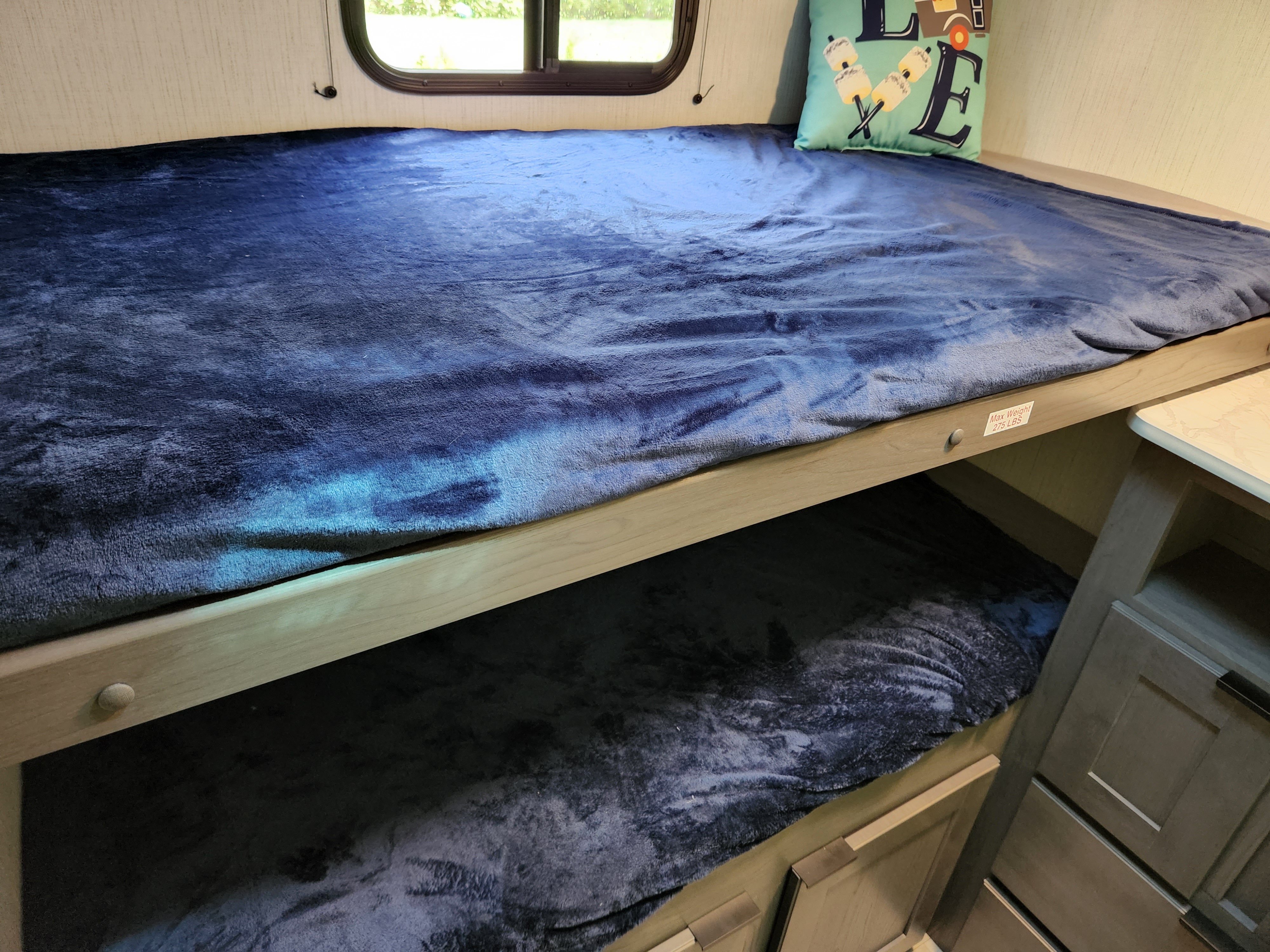 Cozy RV rental bunk beds, perfect for camping. Features soft blue blankets and window. Max weight 275 lbs.. Cruiser Embrace el280 2022