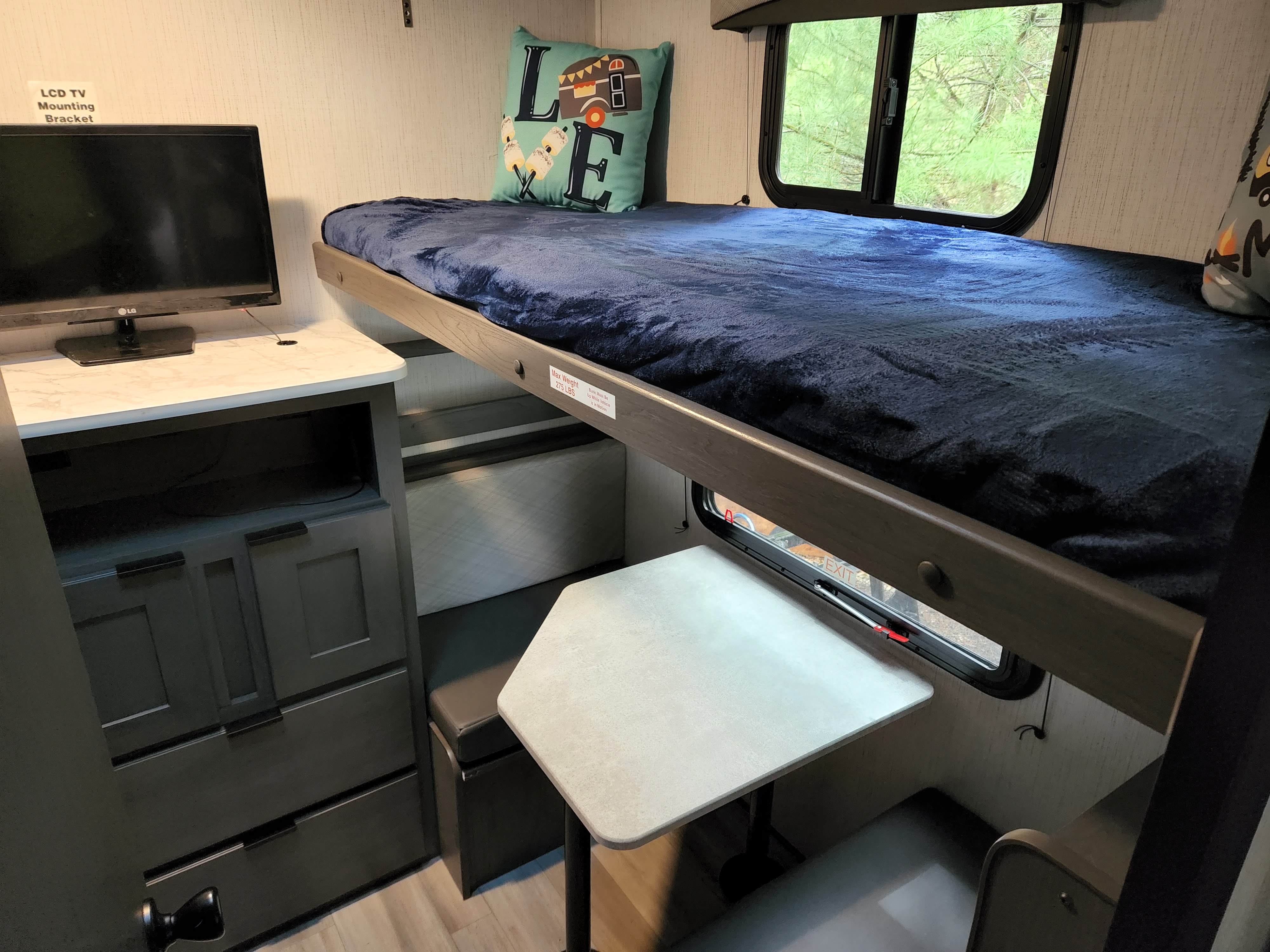 Cozy RV rental interior featuring a comfortable bunk bed, convertible dinette, and entertainment area. Ideal for family trips.. Cruiser Embrace el280 2022