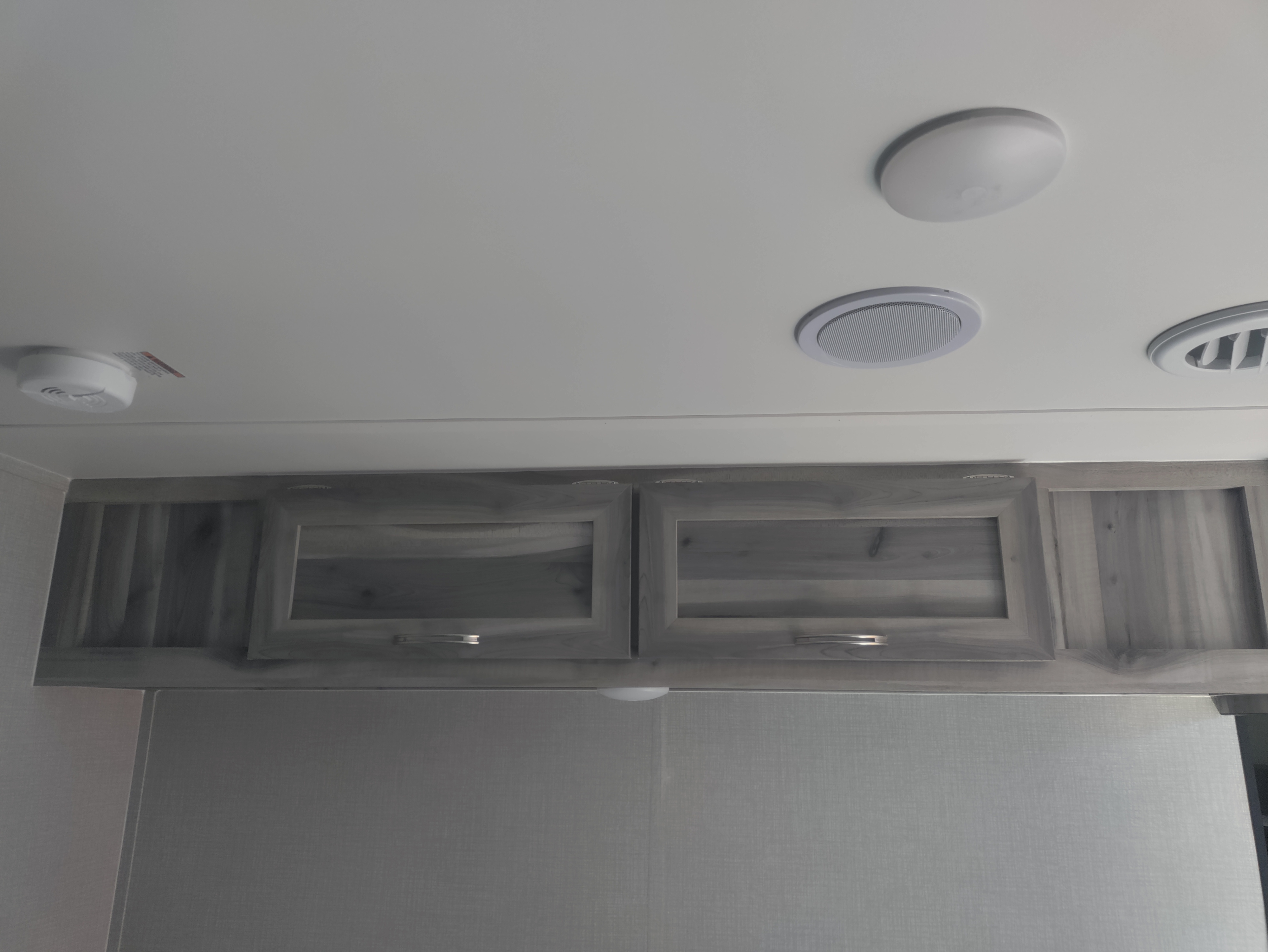 RV rental: Overhead cabinets, ceiling lights, speaker, air vent, & smoke detector in modern interior.. Chinook Dream bunkhouse 2022