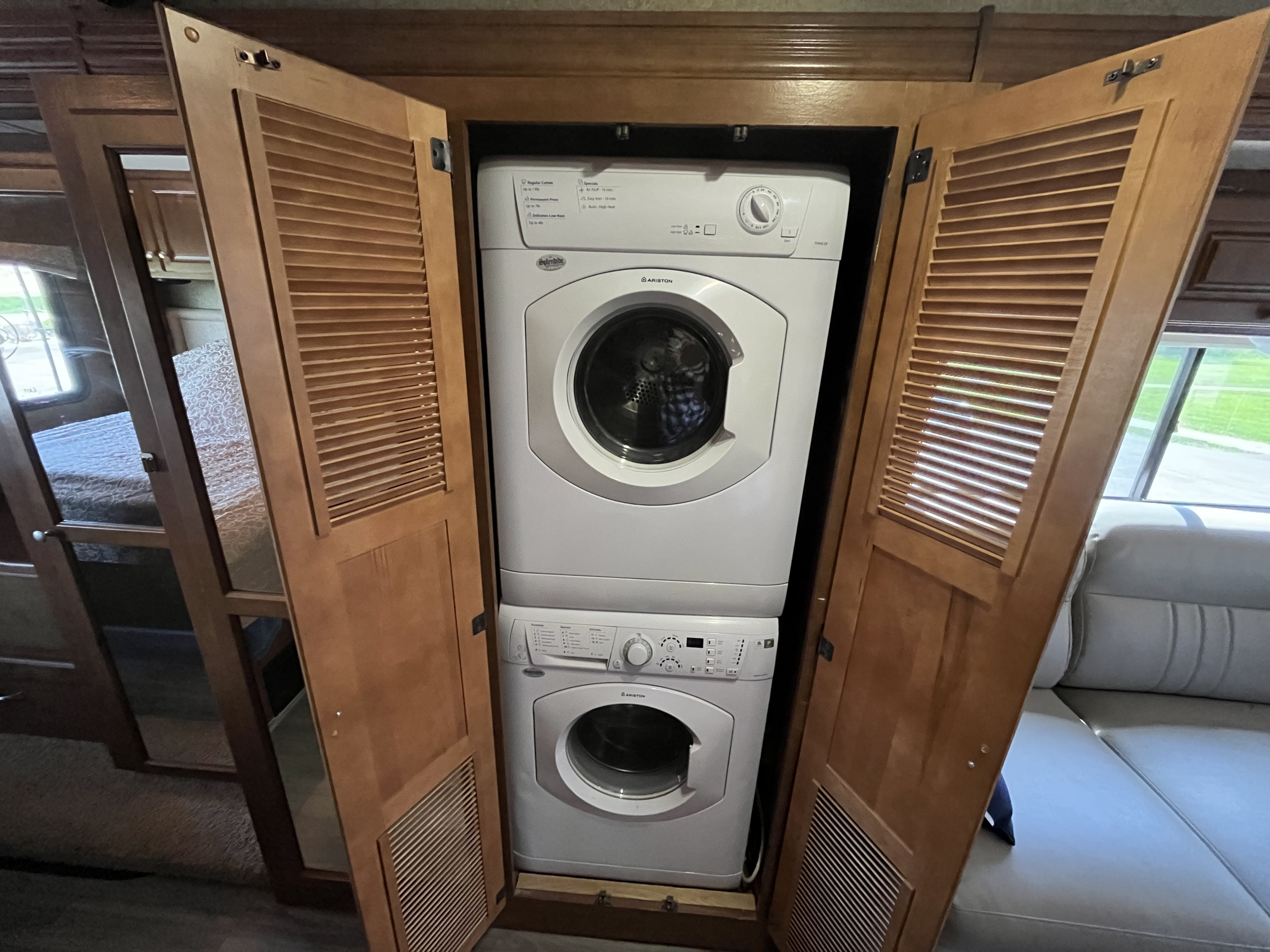 Stay fresh on your RV rental journey! This motorhome offers a compact, stackable washer and dryer unit, visible behind open louvered doors.. Other Miramar 2014