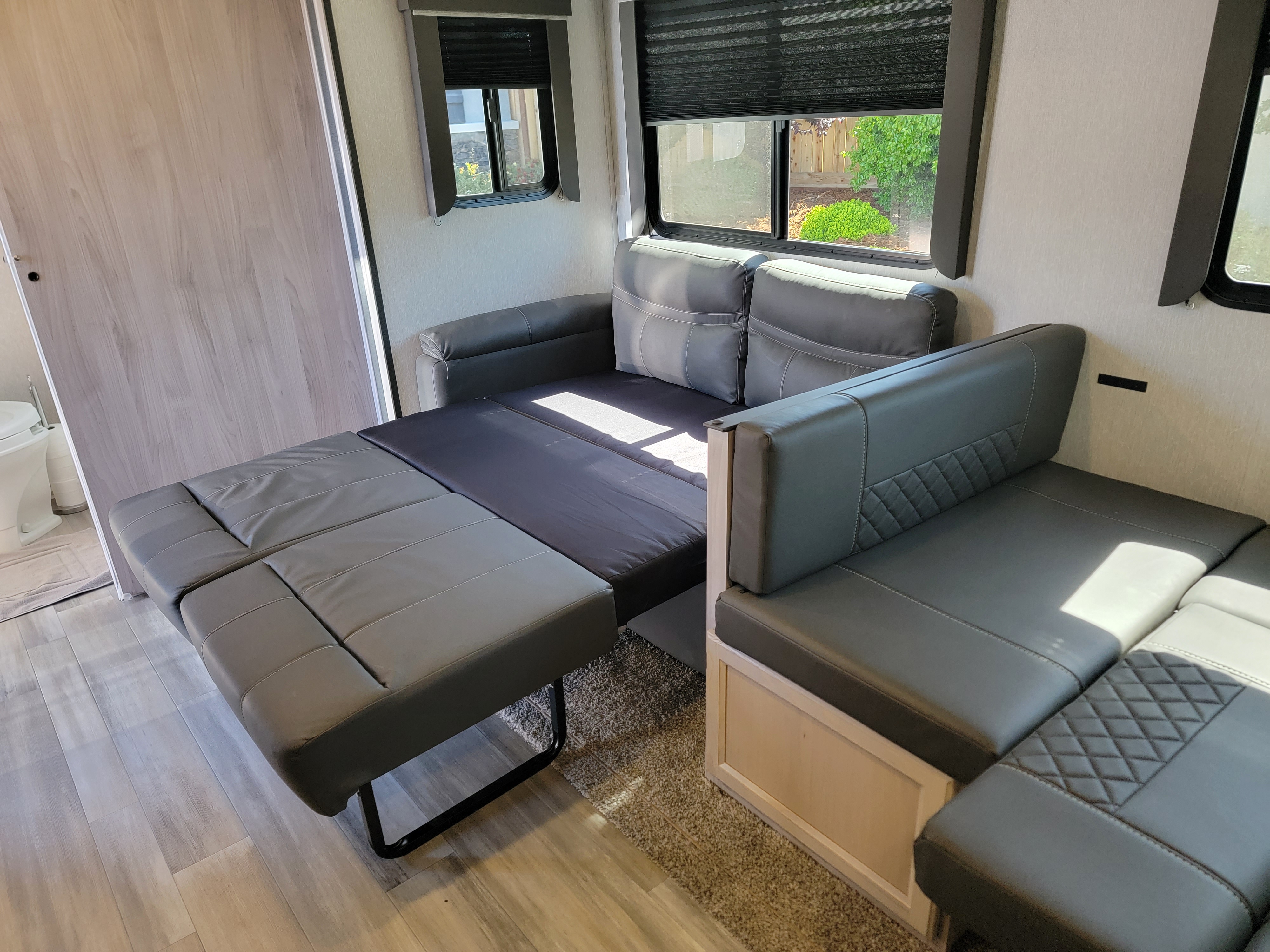 RV rental: Gray sofa transforms into a bed, alongside dinette seating, optimizing space in this modern interior.. Coachmen Spirit Ultra Lite 2021