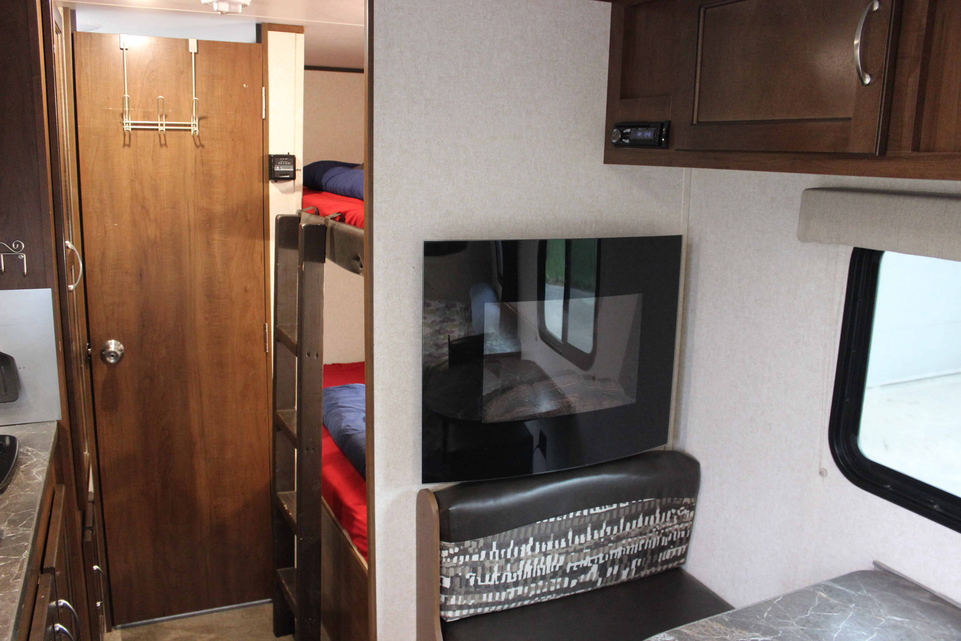 Inside an RV rental, featuring bunk beds, a TV, a dinette, and a partial kitchen counter. Ready for adventure!. Jayco Jay Flight SLX 2017