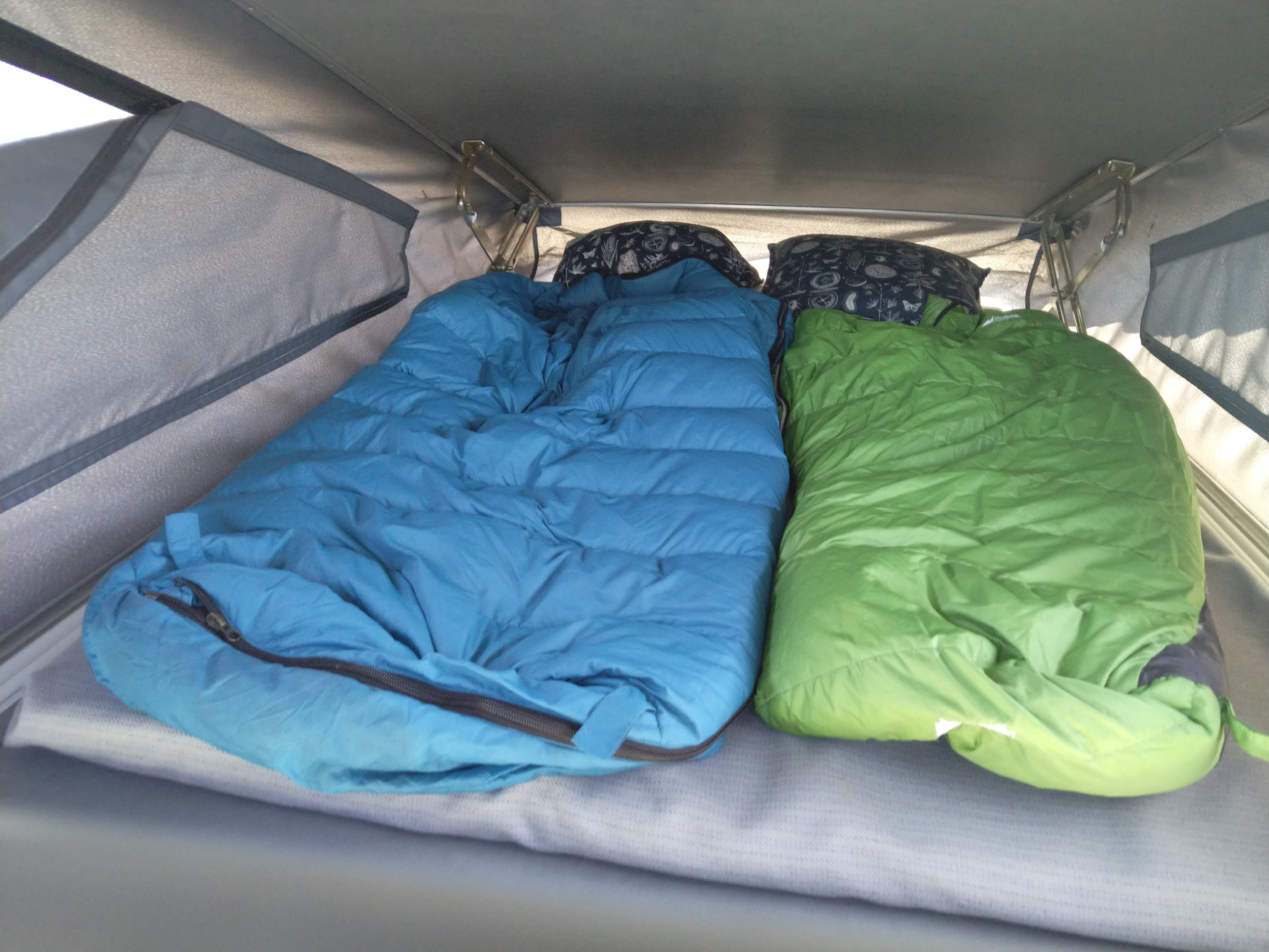 RV rental bed with blue and green sleeping bags and pillows, ready for camping trips.. Westfalia T3 Westfalia 1993