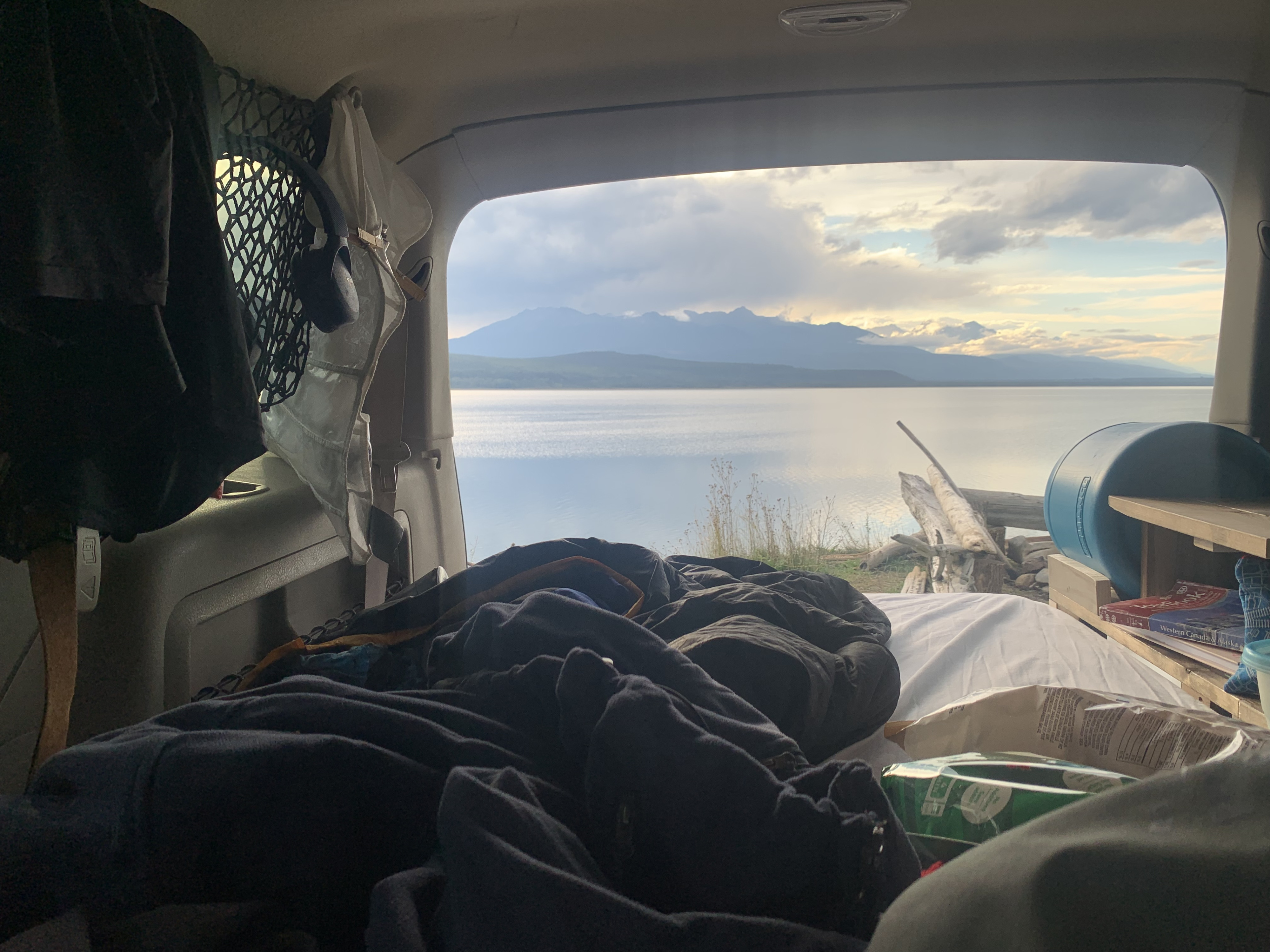 Cozy RV rental interior with bed, offering stunning lake and mountain views. Ideal for travel and car camping trips.. Ford Expplorer 2006