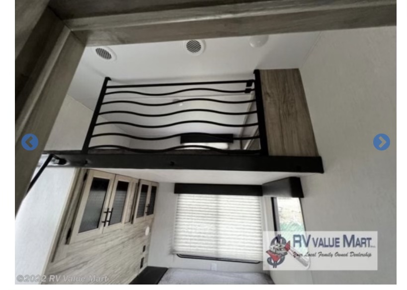 Check out this RV rental! Upper bunk with modern wavy railing, storage cabinets, and window with blinds.. Forest River Cherokee Arctic Wolf 2021