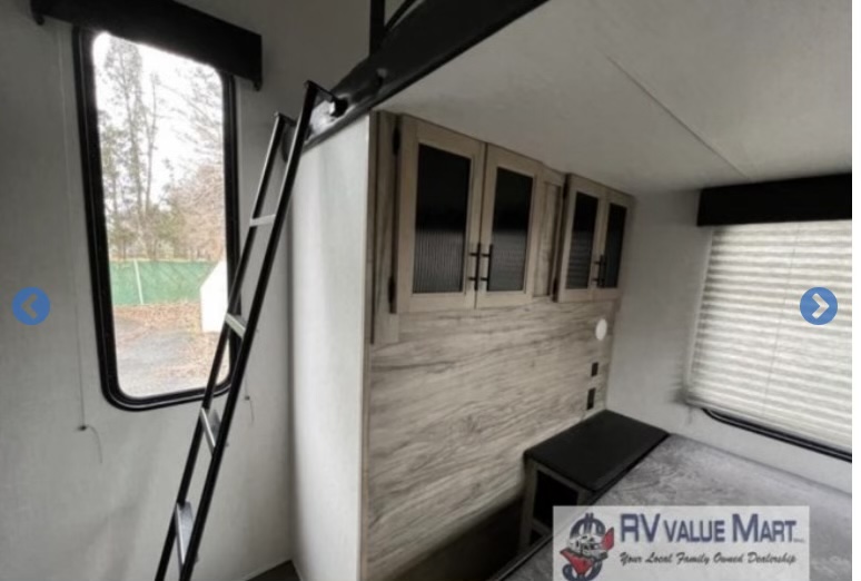 RV rental interior featuring a bunk ladder, bed, and overhead cabinets for a compact, functional camper space.. Forest River Cherokee Arctic Wolf 2021