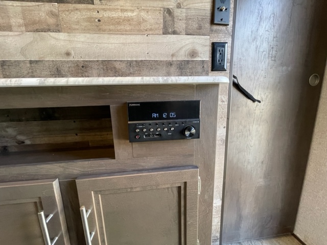 Functional RV rental interior showing a Furrion entertainment system, wood-like walls, and ample cabinet storage.. Dutchmen Aspen Trail Trailer 2020