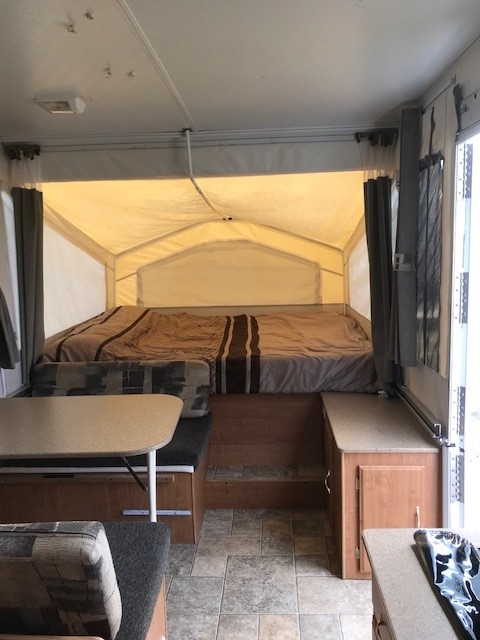 RV rental: Bright pop-up camper interior, showing a bed, dinette, and counter space.. Forest River Rockwood Freedom 2007