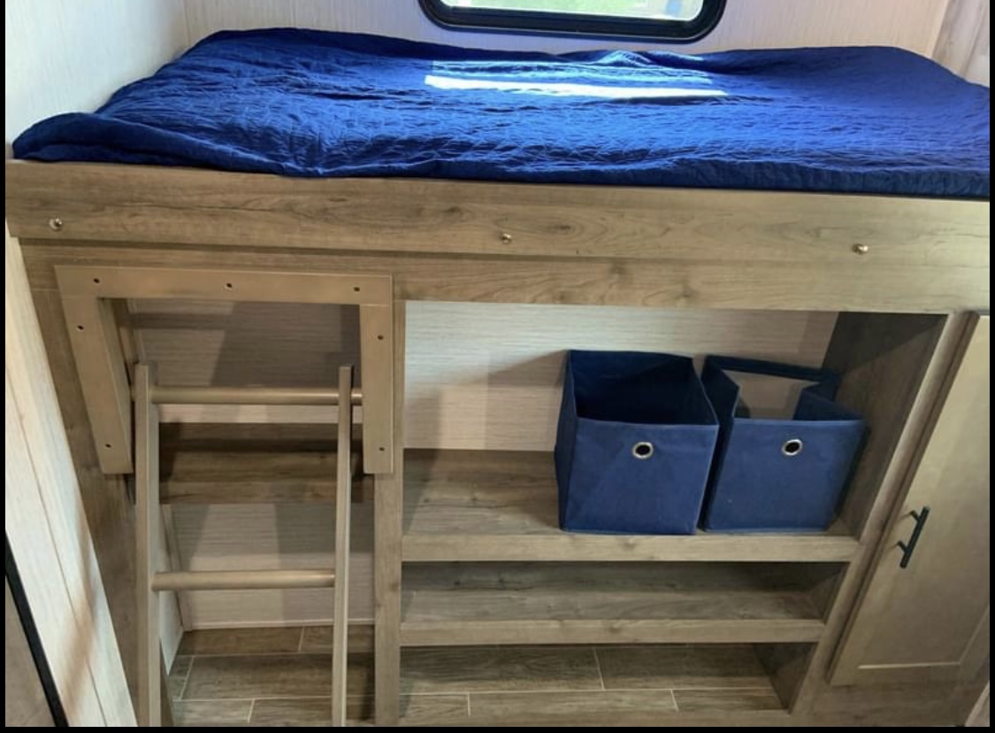 RV rental: Cozy bunk bed with ladder, shelves, and blue storage bins for your journey.. Forest River Palomino Puma 2020