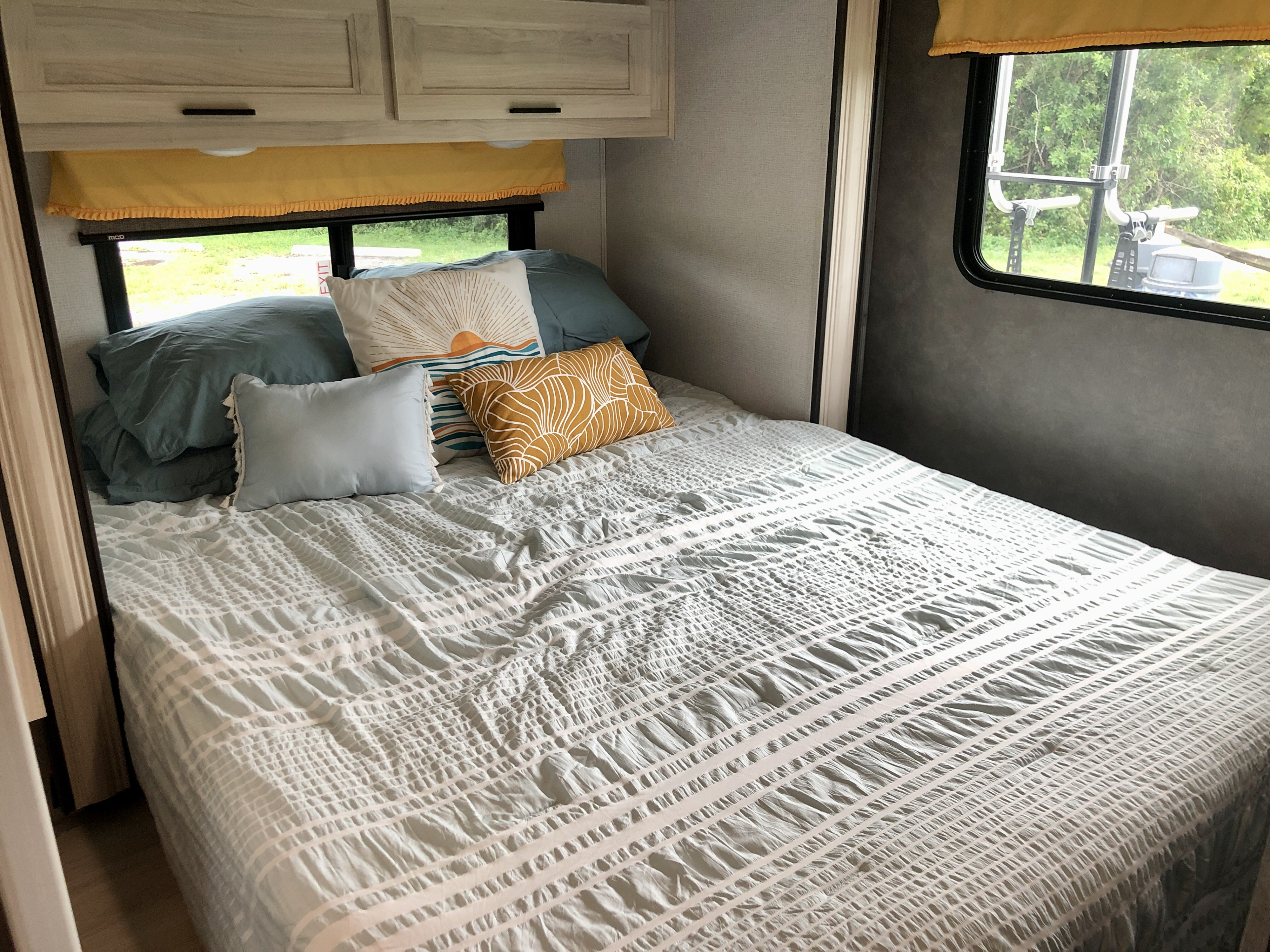 RV rental: inviting bedroom with light-colored bedding, bright throw pillows, and overhead storage.. Forester LE 2020