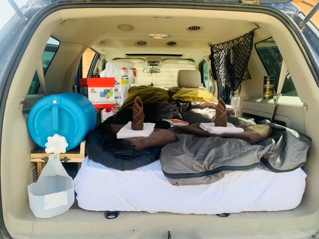 DIY RV rental: SUV cargo area equipped for car camping with a bed, water dispenser, and supplies.. Ford Expplorer 2006