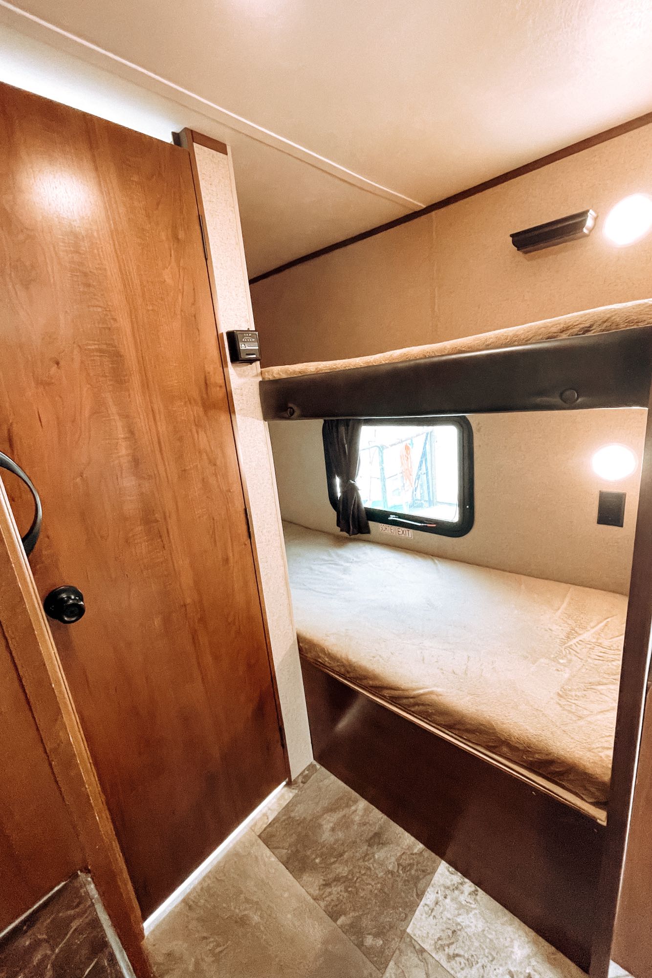 RV rental interior features bunk beds, a window, and a door, providing comfortable camper accommodation.. Jayco Jay Flight SLX 2016