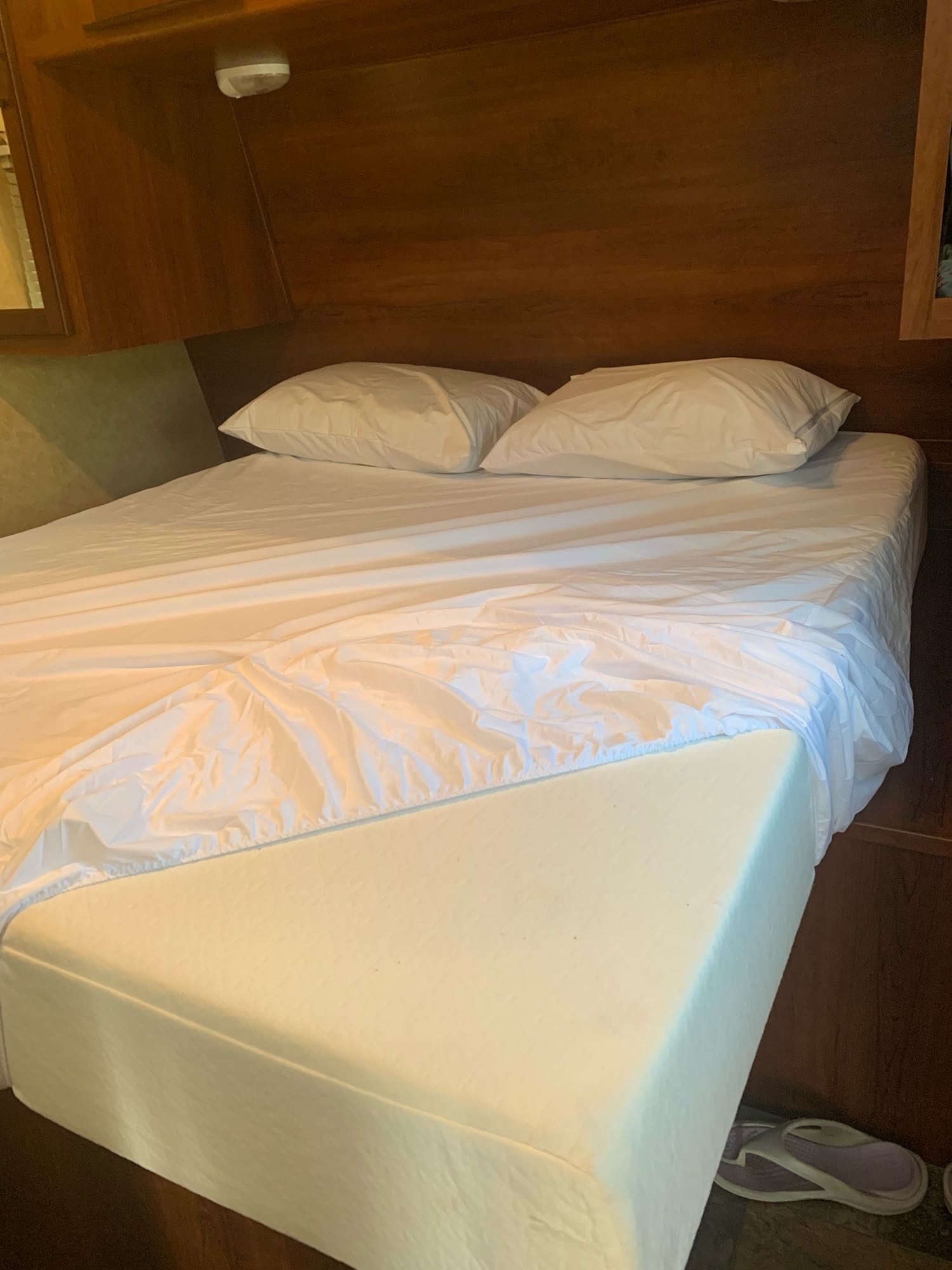 RV rental bed with crisp white sheets partially pulled back, revealing a comfortable foam mattress. Ready for your stay.. Prime Time Avenger 2013