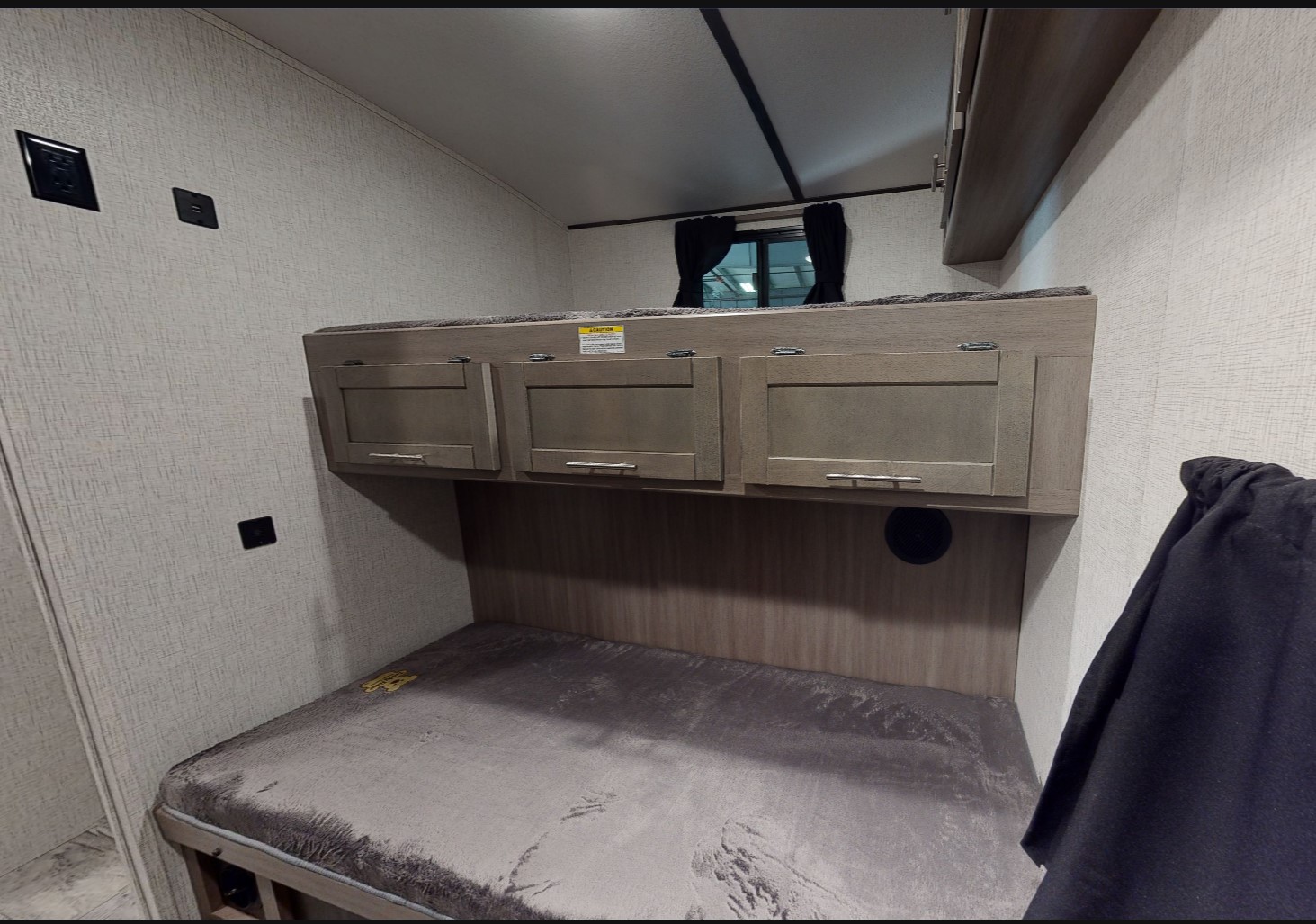 Interior of an RV showing practical bunk beds with built-in storage, outlets, and a window for your rv rental.. Crossroads RV Sunset Trail Super Lite 2021