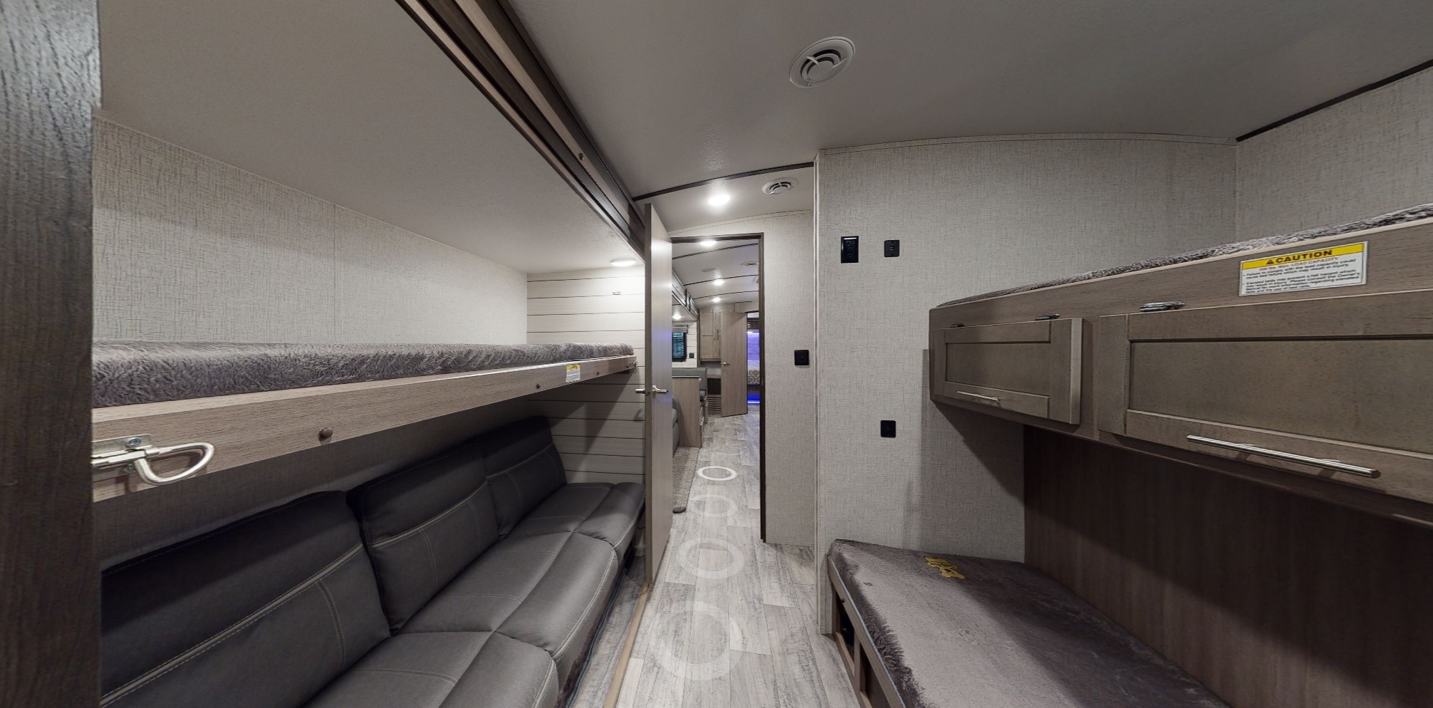RV rental interior: A compact bunkhouse featuring bunk beds on both sides, a lower sofa, and an aisle leading to the main living area.. Crossroads RV Sunset Trail Super Lite 2021