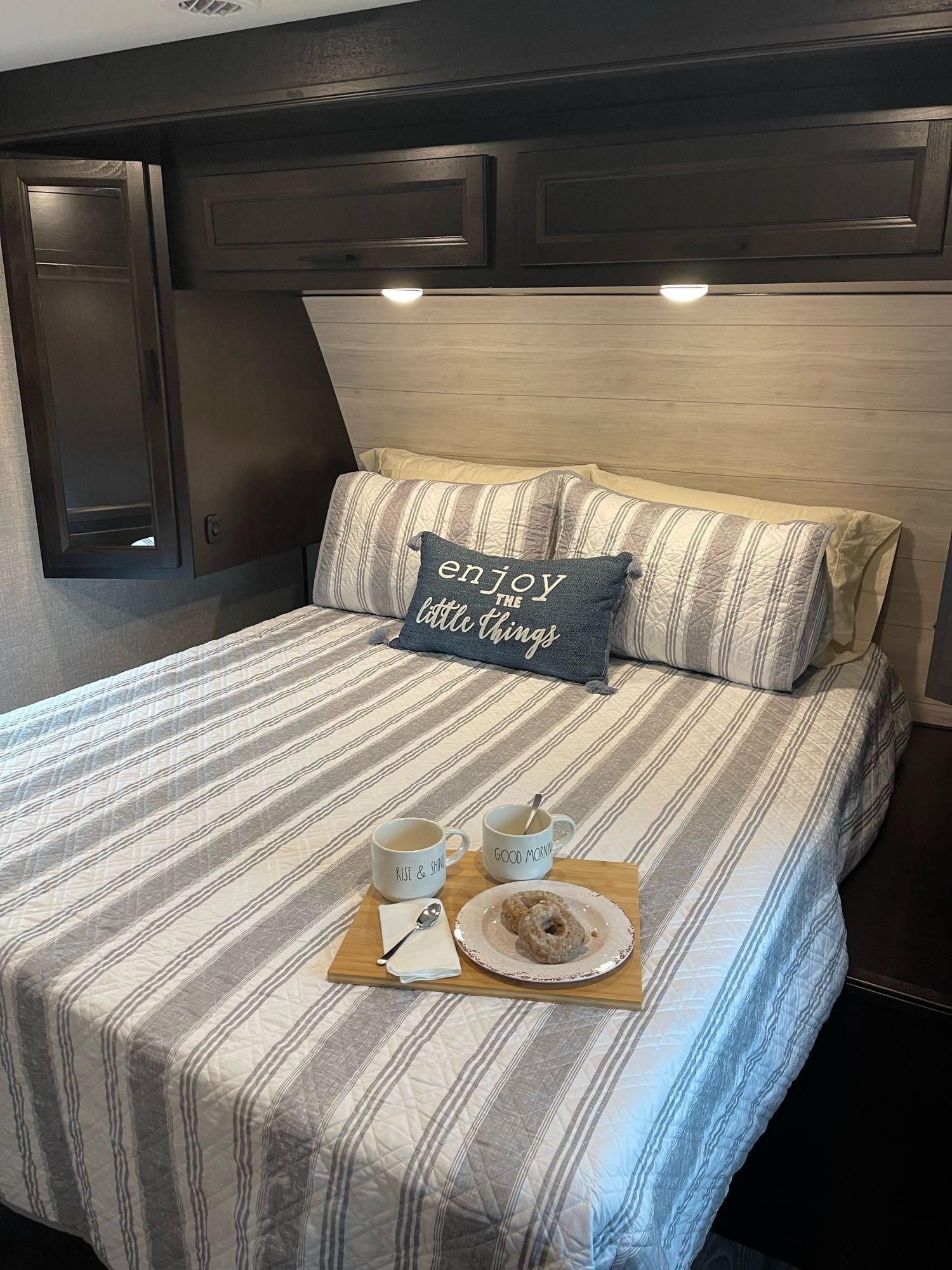 Cozy RV rental bedroom with breakfast in bed and striped bedding. Perfect mobile retreat.. Jayco Eagle HT 312BHOK 2022