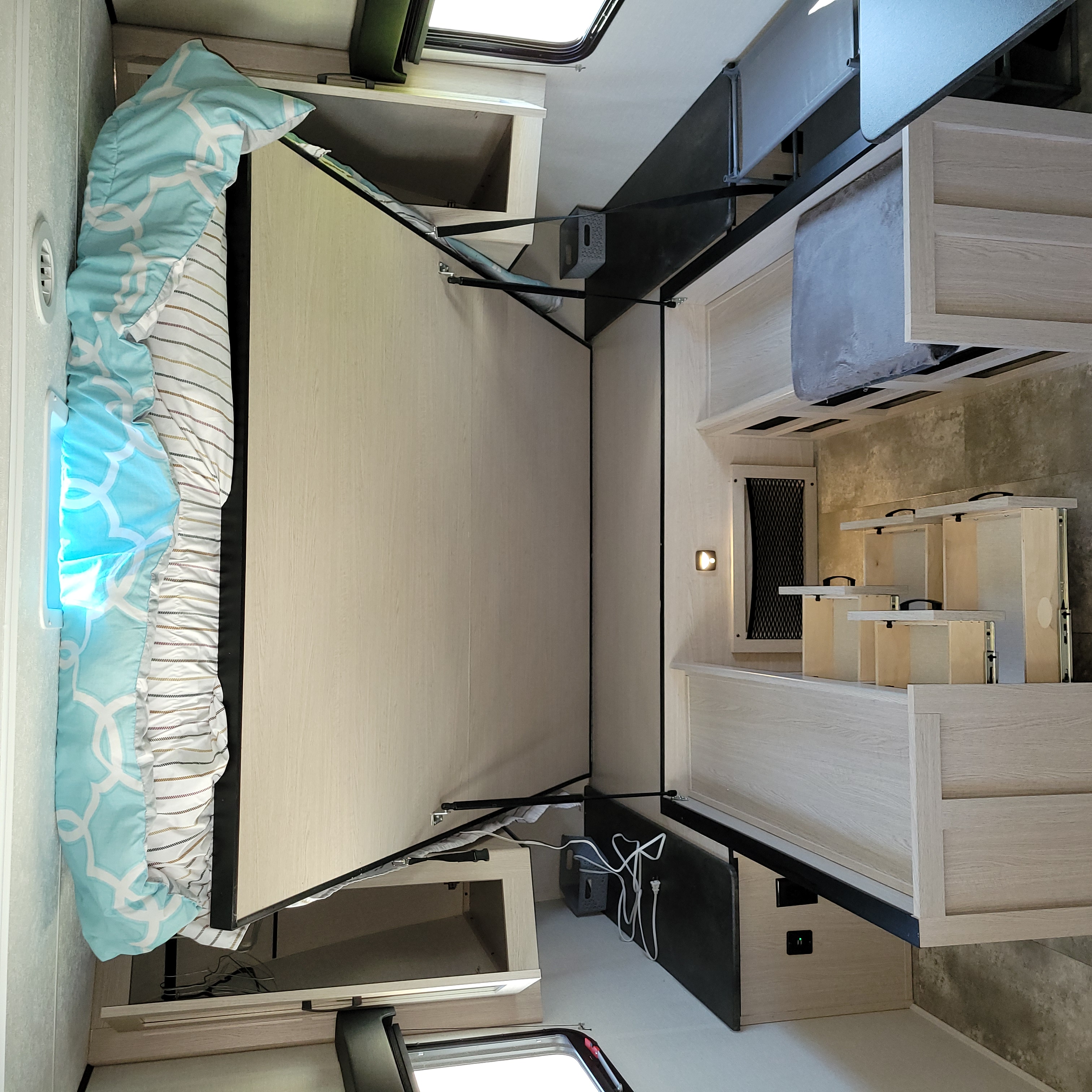 Compact RV rental: interior with space-saving folded murphy bed and light wood storage.. Coachmen Apex Ultra-Lite 211 RBS 2022