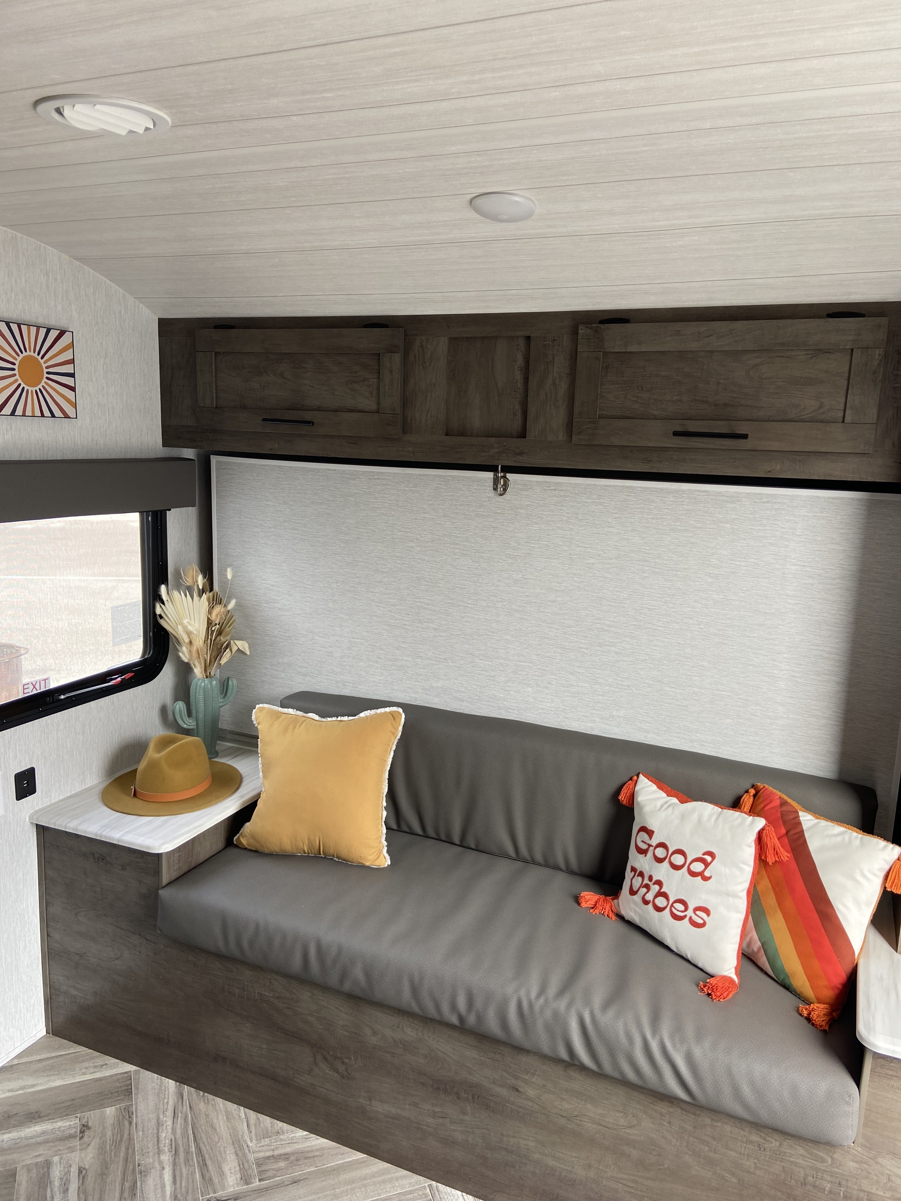 RV rental interior: A modern living space with a grey sofa, colorful pillows, storage cabinets, and boho decor.. Forest River Salem Hemisphere 2022