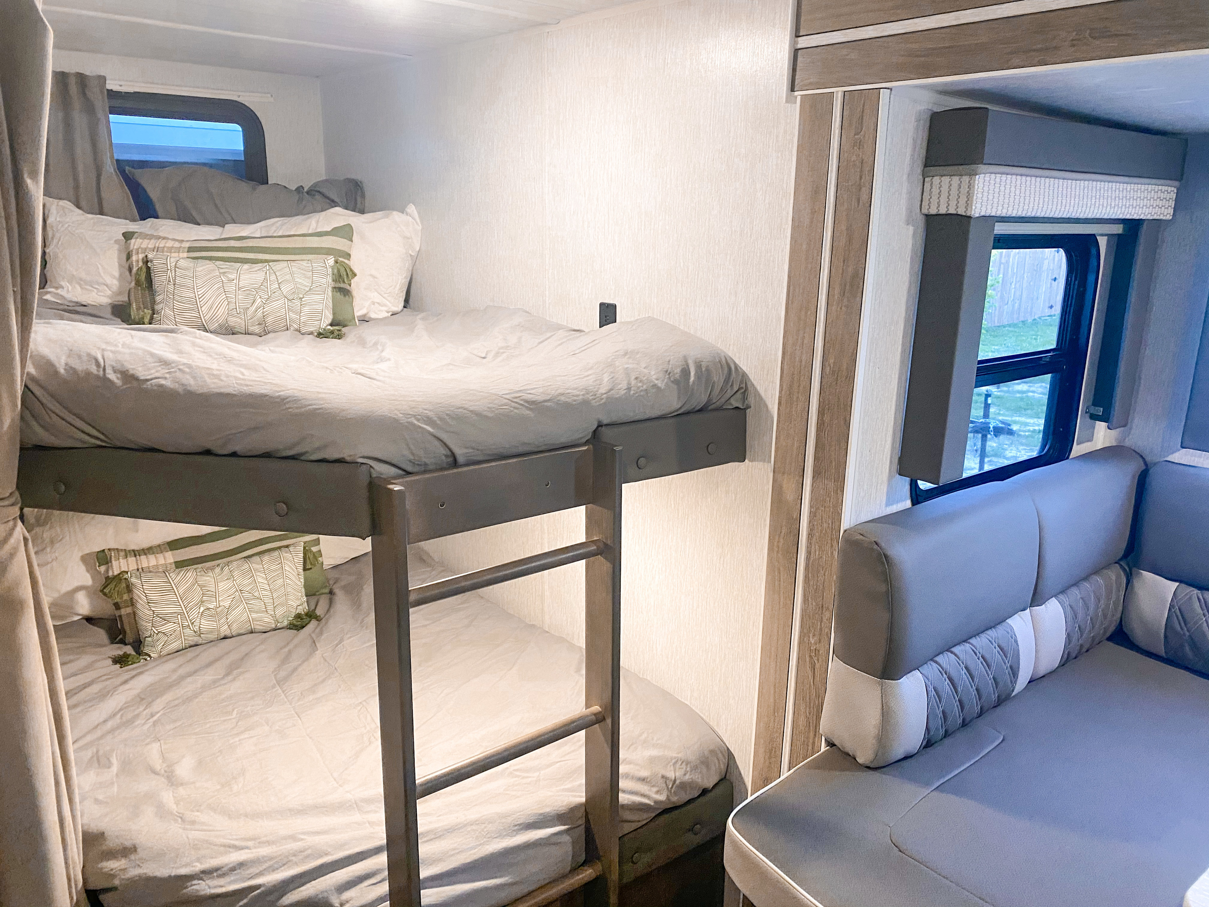 RV rental interior featuring modern bunk beds with light gray bedding, ladder, and a comfortable gray dinette.. Forest River Salem Cruise Lite 2022